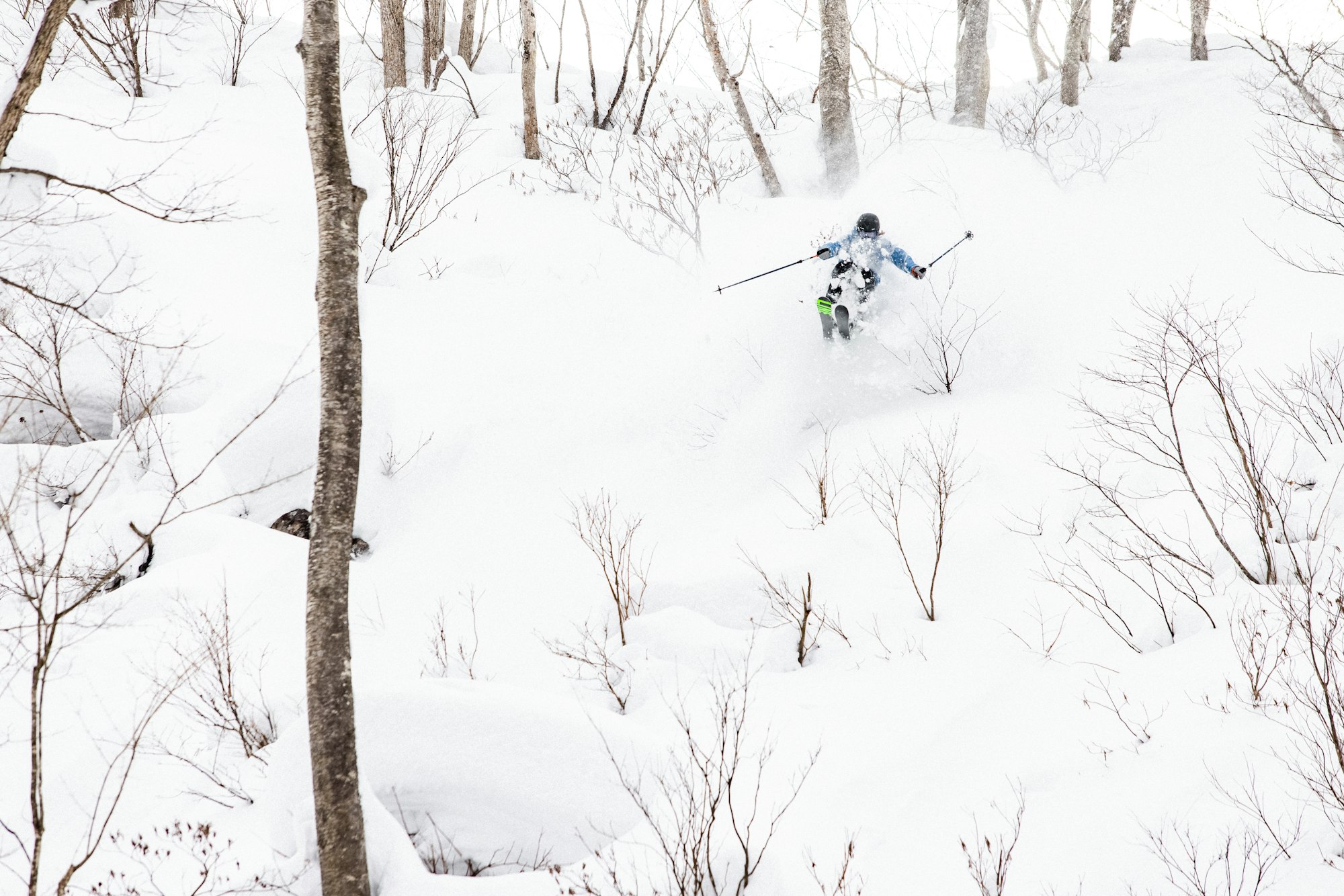 Skier Robert Ruud skiing through deep snow in the woods