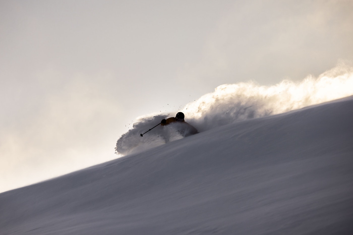 Skier skis down a slope with deep snow