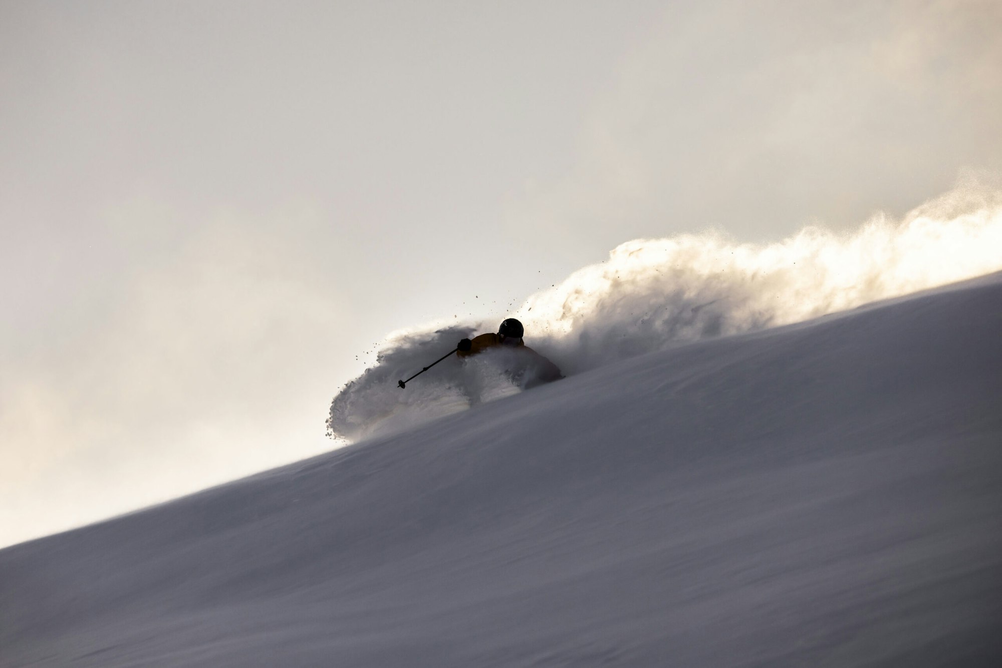 Skier skis down a slope with deep snow