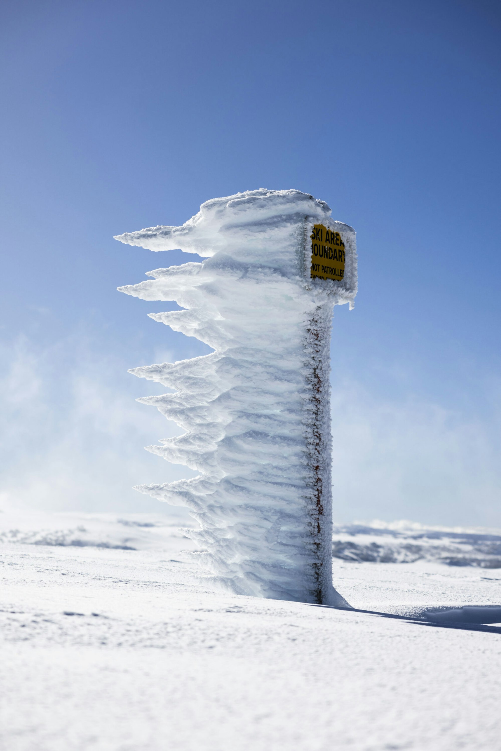 Ski area boundary sign with blown snow crystals attached to it
