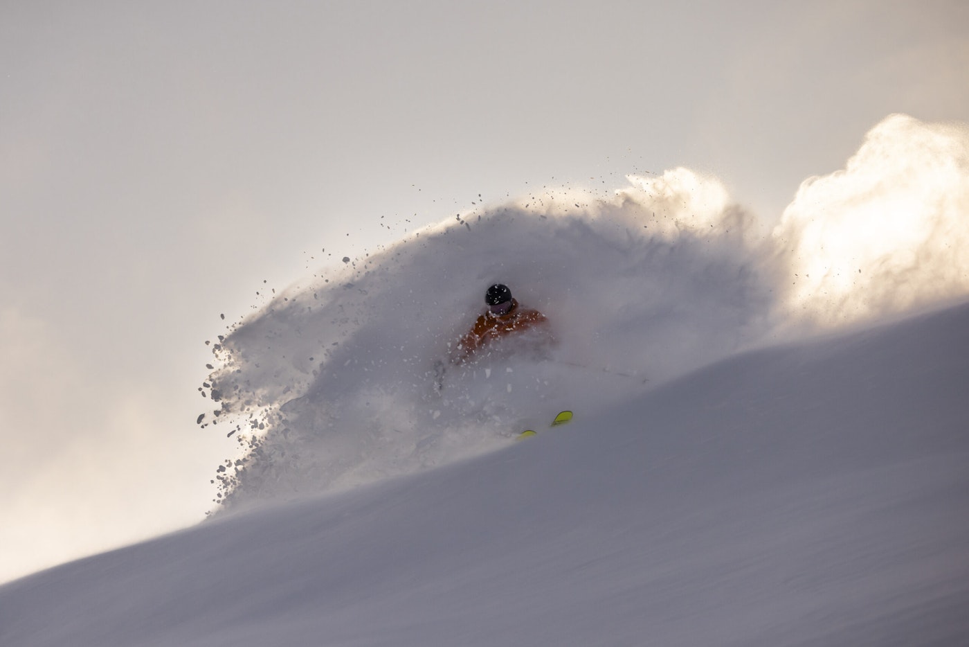 Skier turns in deep snow on the side of a mountain