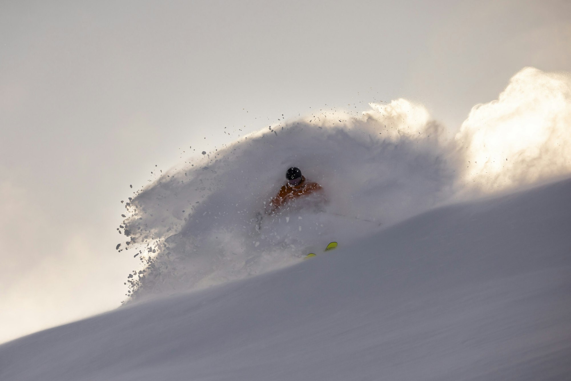 Skier turns in deep snow on the side of a mountain