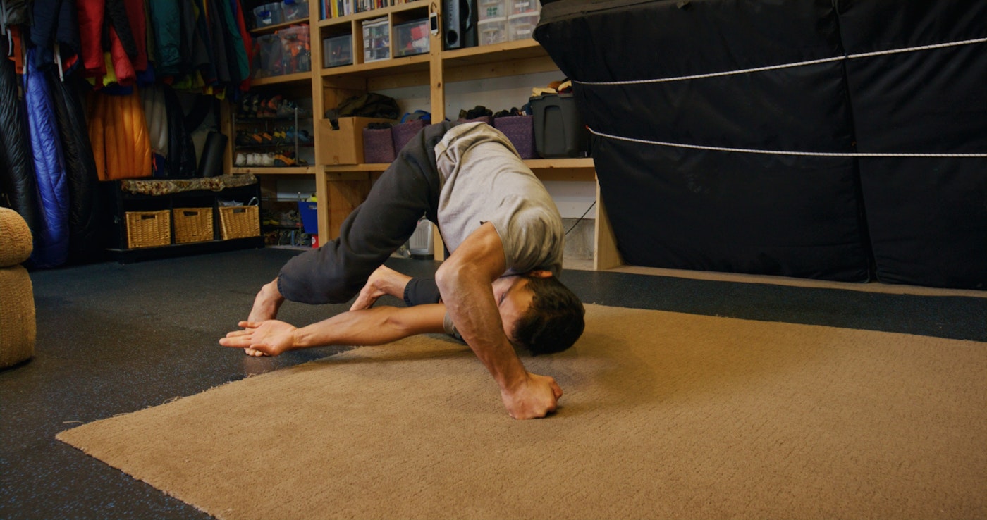 Skier Zahan Billimoria stretches on his floor