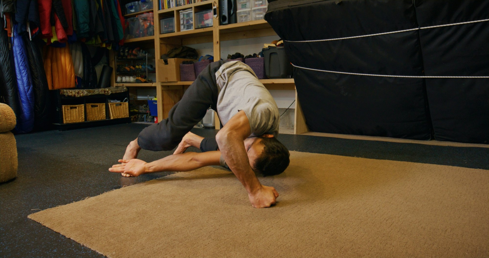 Skier Zahan Billimoria stretches on his floor