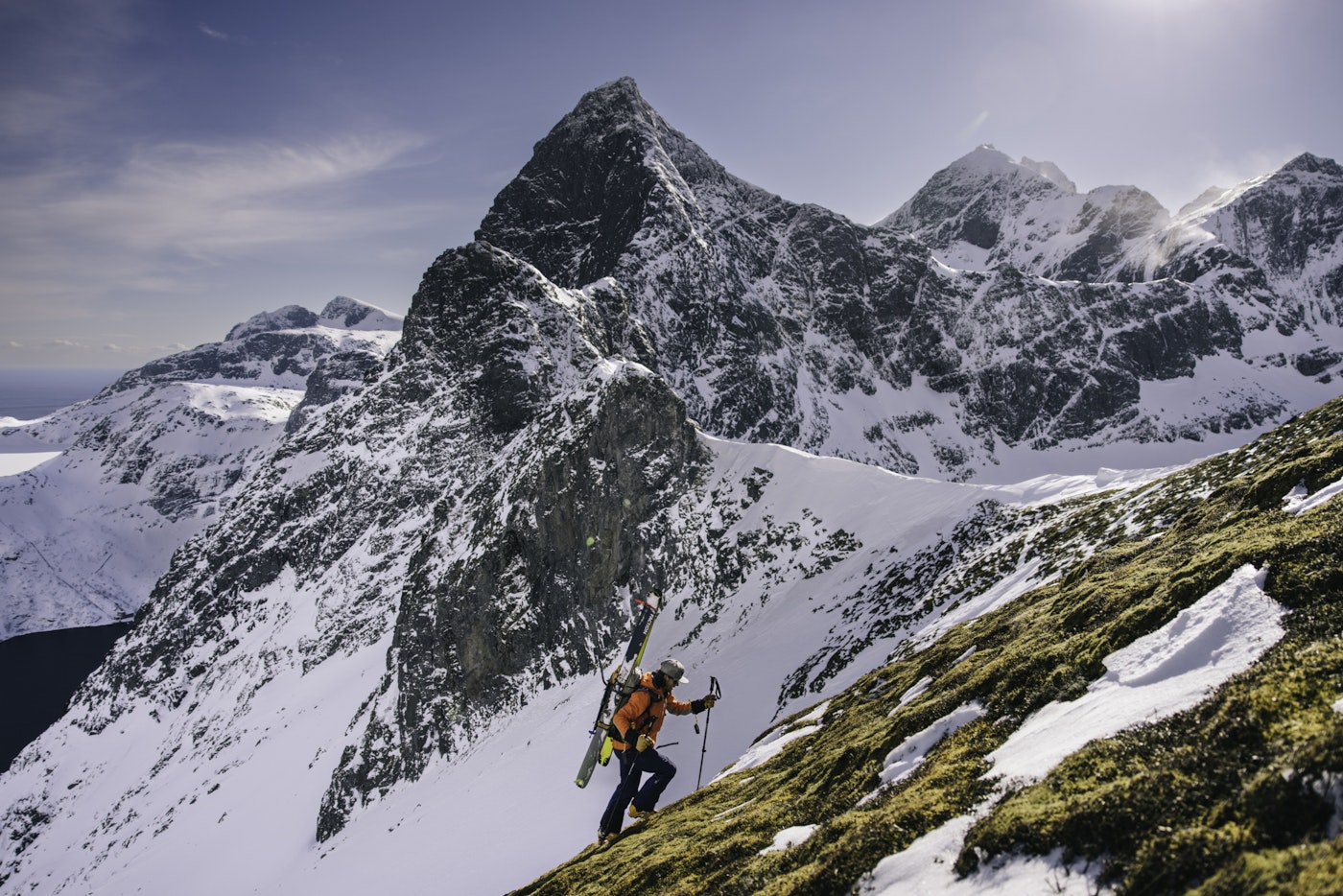 Skier hikes along a mountain side in the snow