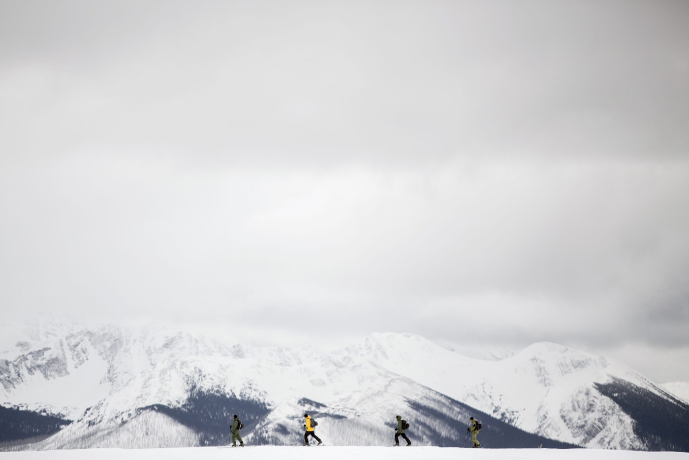 Four skiers Blake Marshall, Abel Moga, Ian Morrison and Jess Hotter walking across the snow in a mountain range at Powder King Mountain Resort