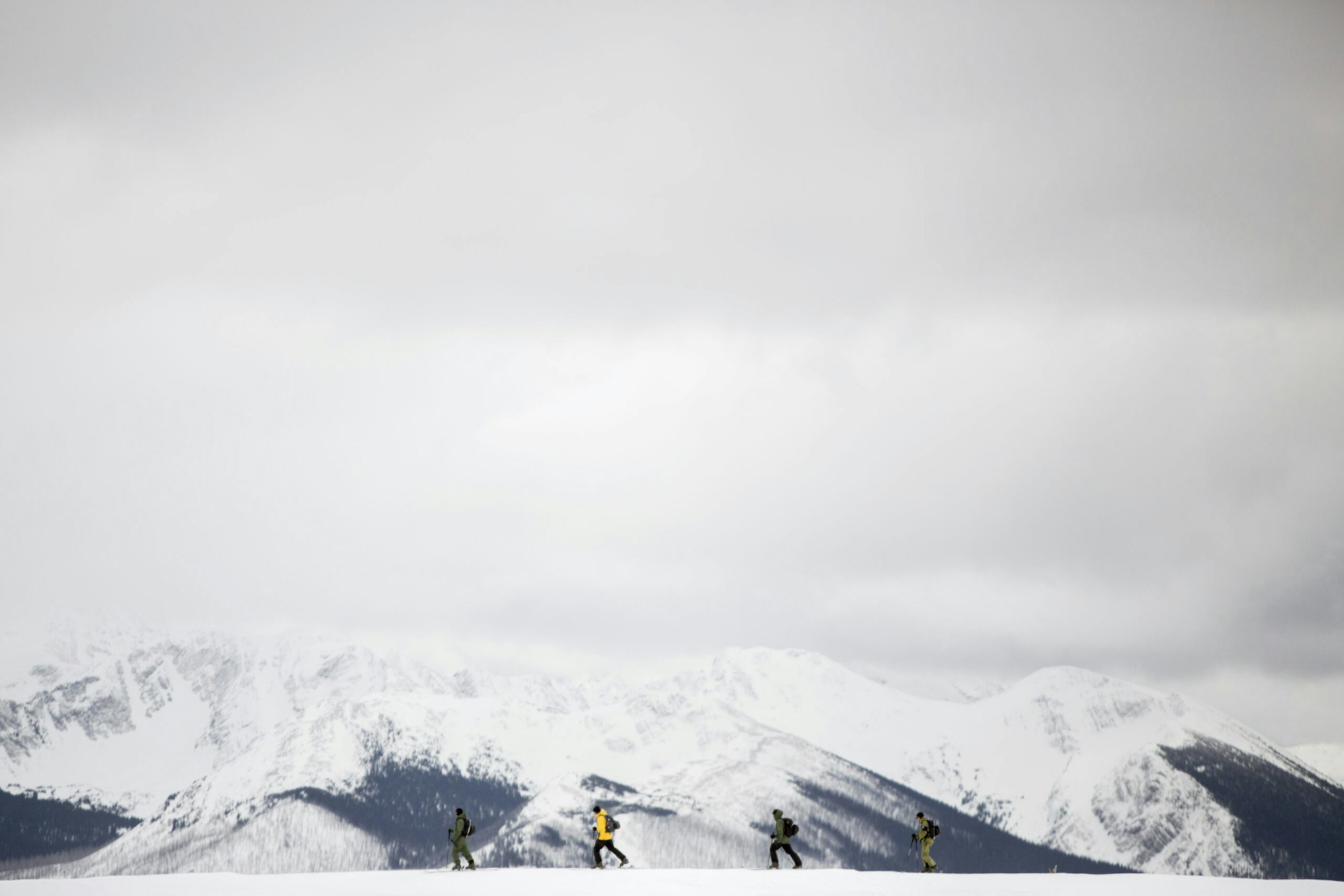 Four skiers Blake Marshall, Abel Moga, Ian Morrison and Jess Hotter walking across the snow in a mountain range at Powder King Mountain Resort