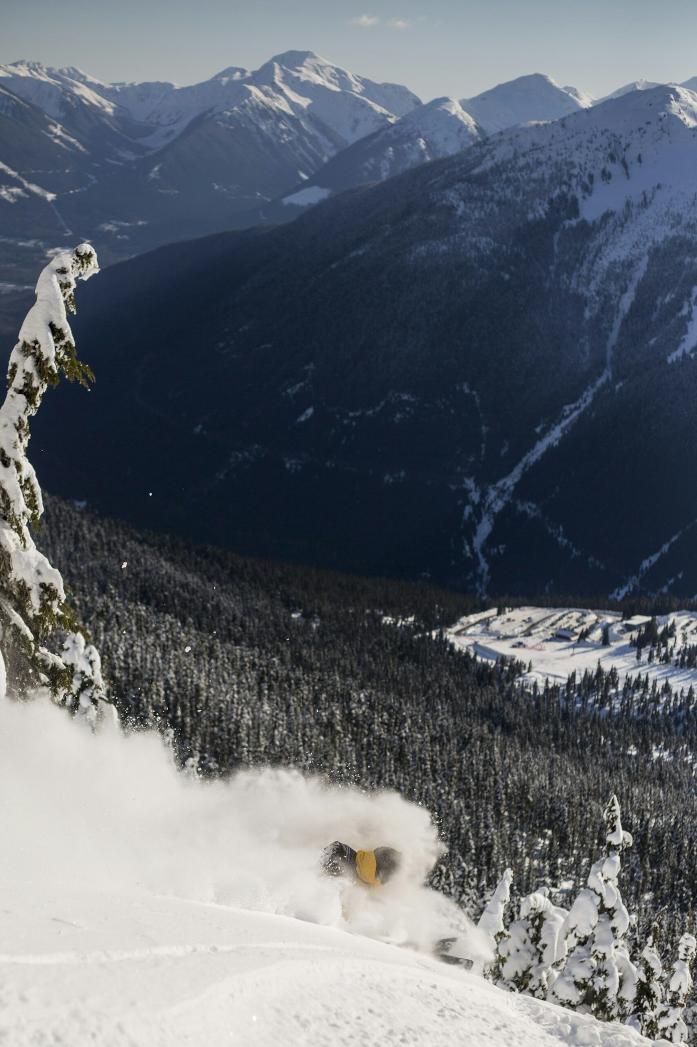 Skier Abel Moga skiing down the side of a snowy mountain in a mountain range