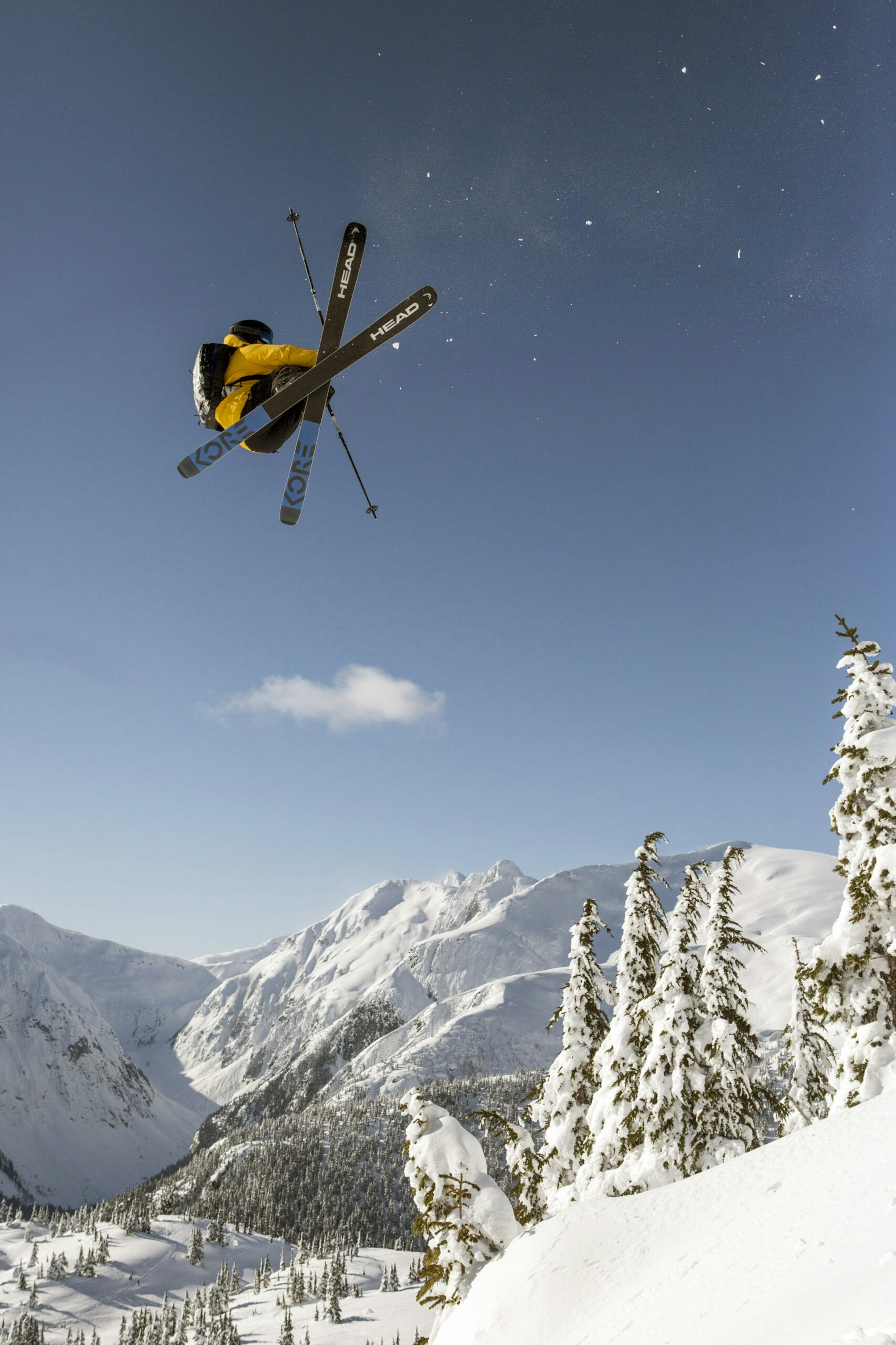 Skier Abel Moga spinning through the air on skis above deep snow on a mountainside