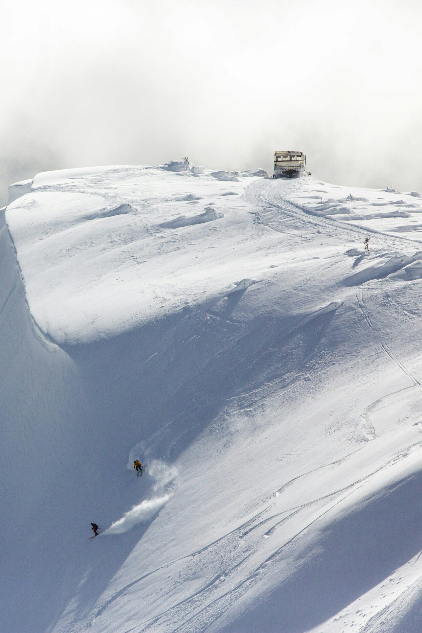 Skiers Yuki Tsubota and Jaret Bull skiing down a snowy mountainside in Smithers, BC