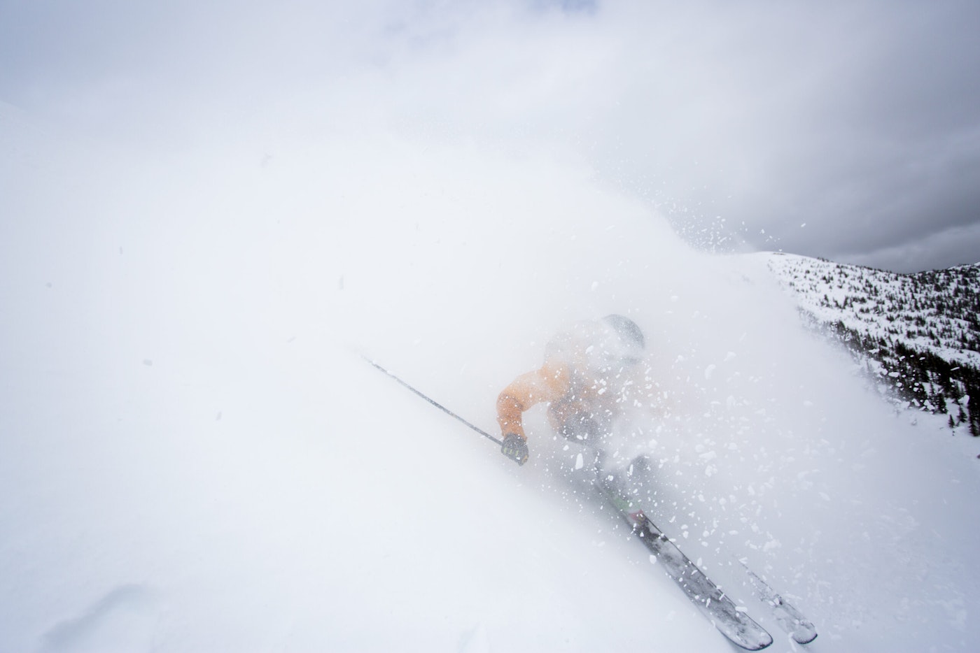 Skier Jaret Bull skiing down a mountain in deep snow in Smithers, BC