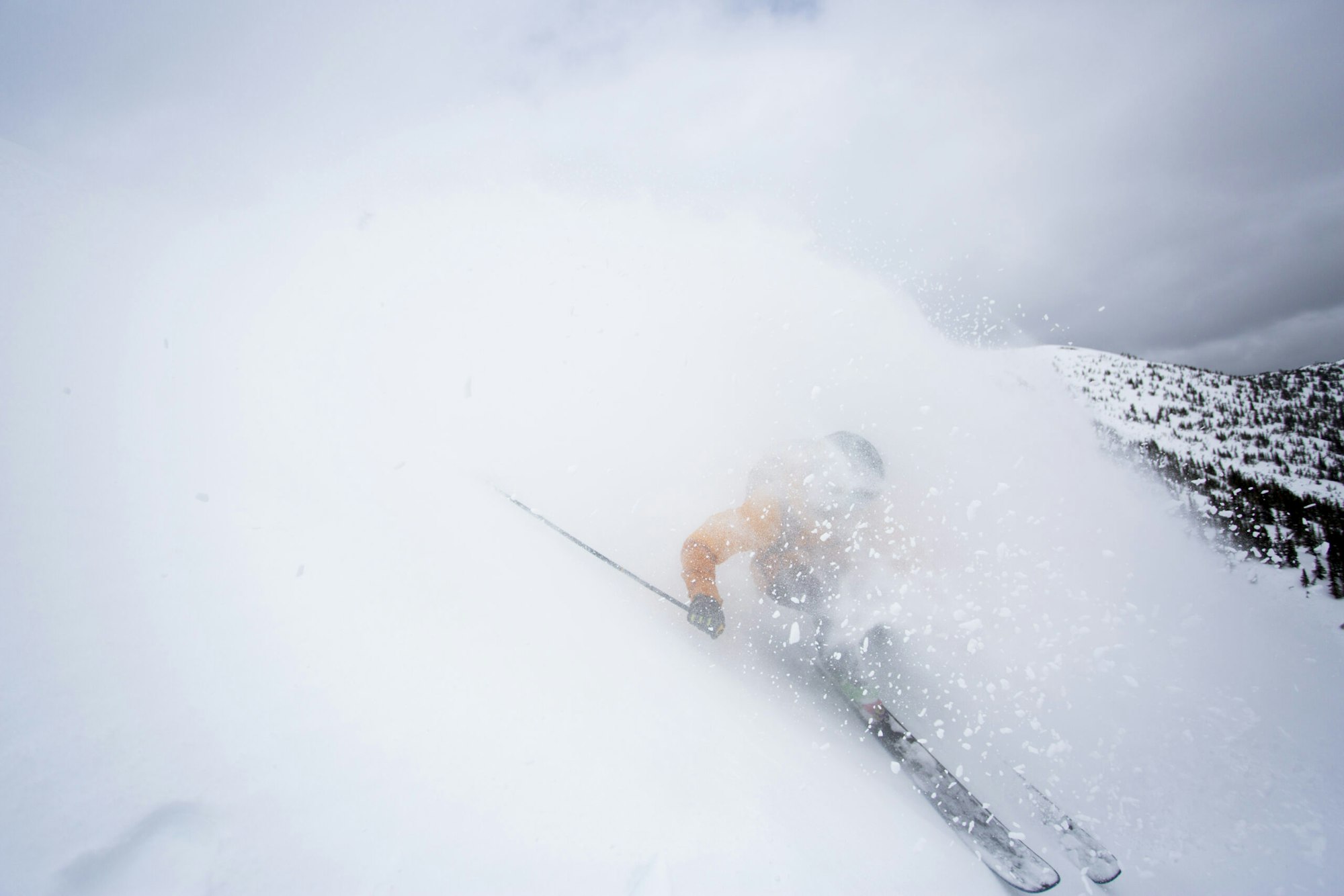 Skier Jaret Bull skiing down a mountain in deep snow in Smithers, BC