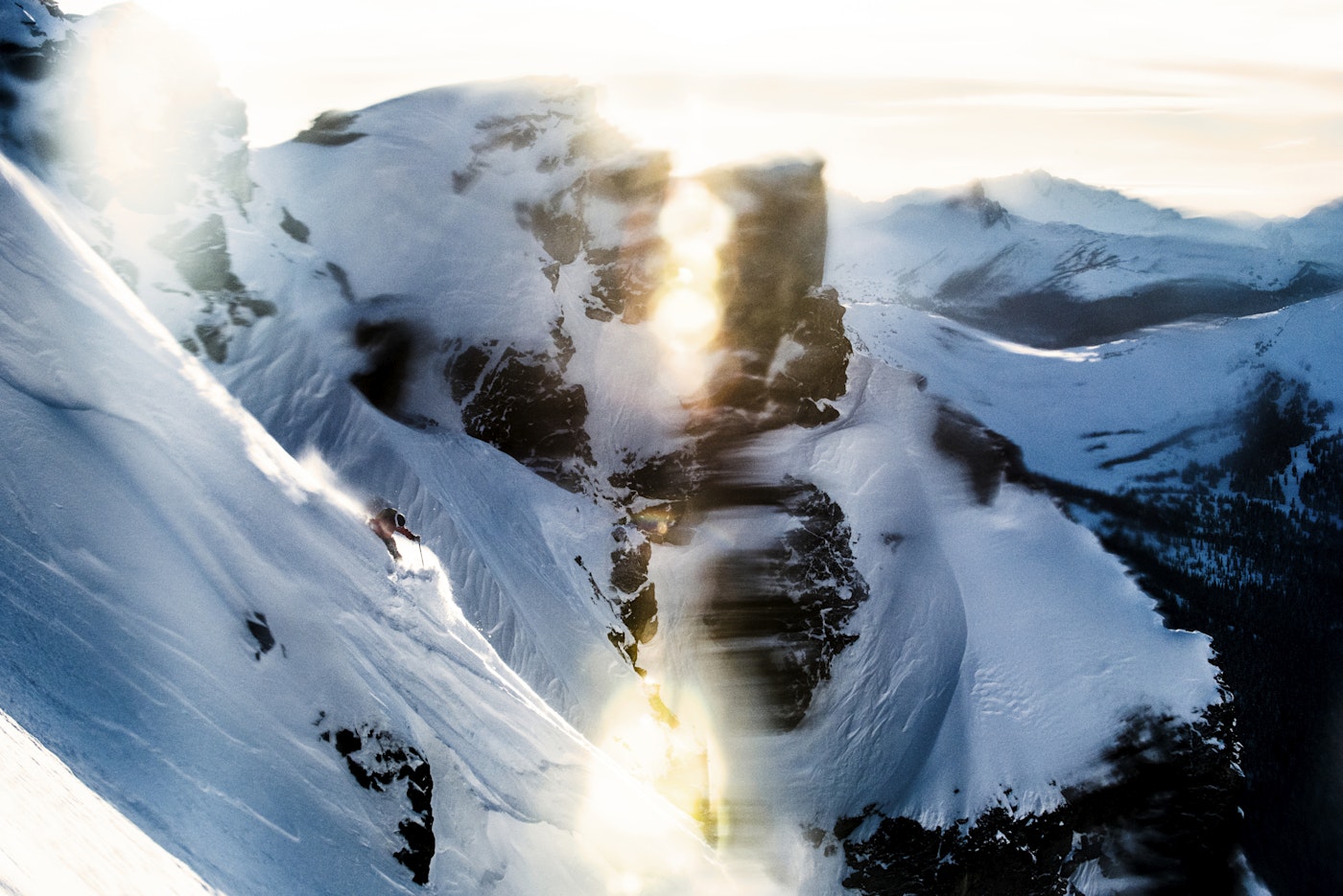 Skier Austin Ross skiing down a snowy, steep mountain face in Whistler, BC