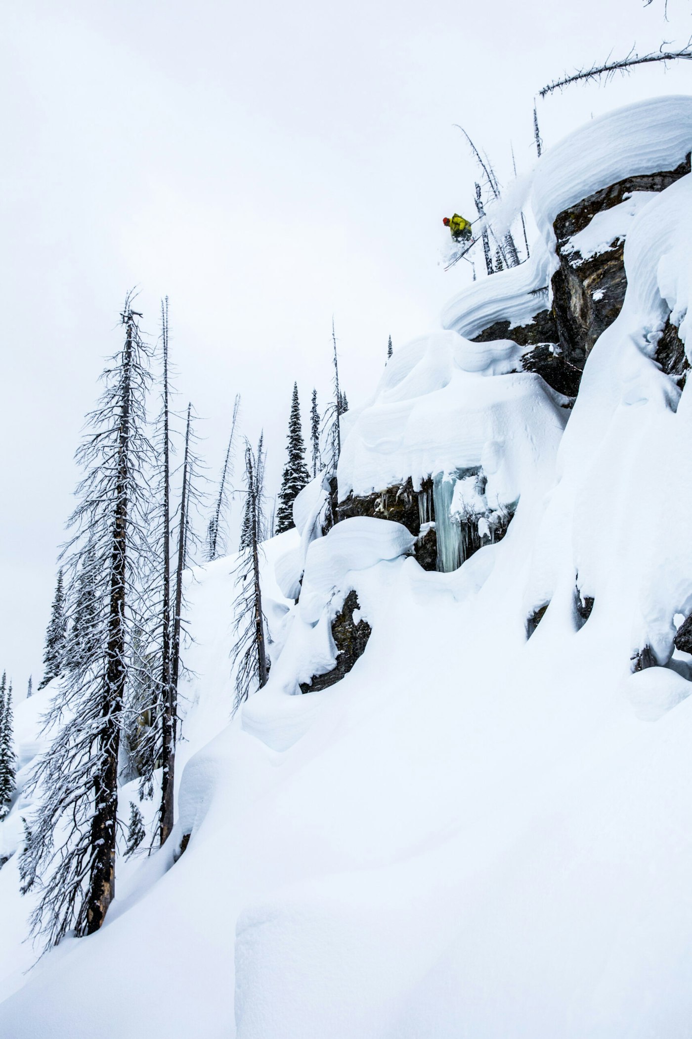 Skier Carter MacMillan jumping from a cliff into deep powder snow in Cherryville, BC