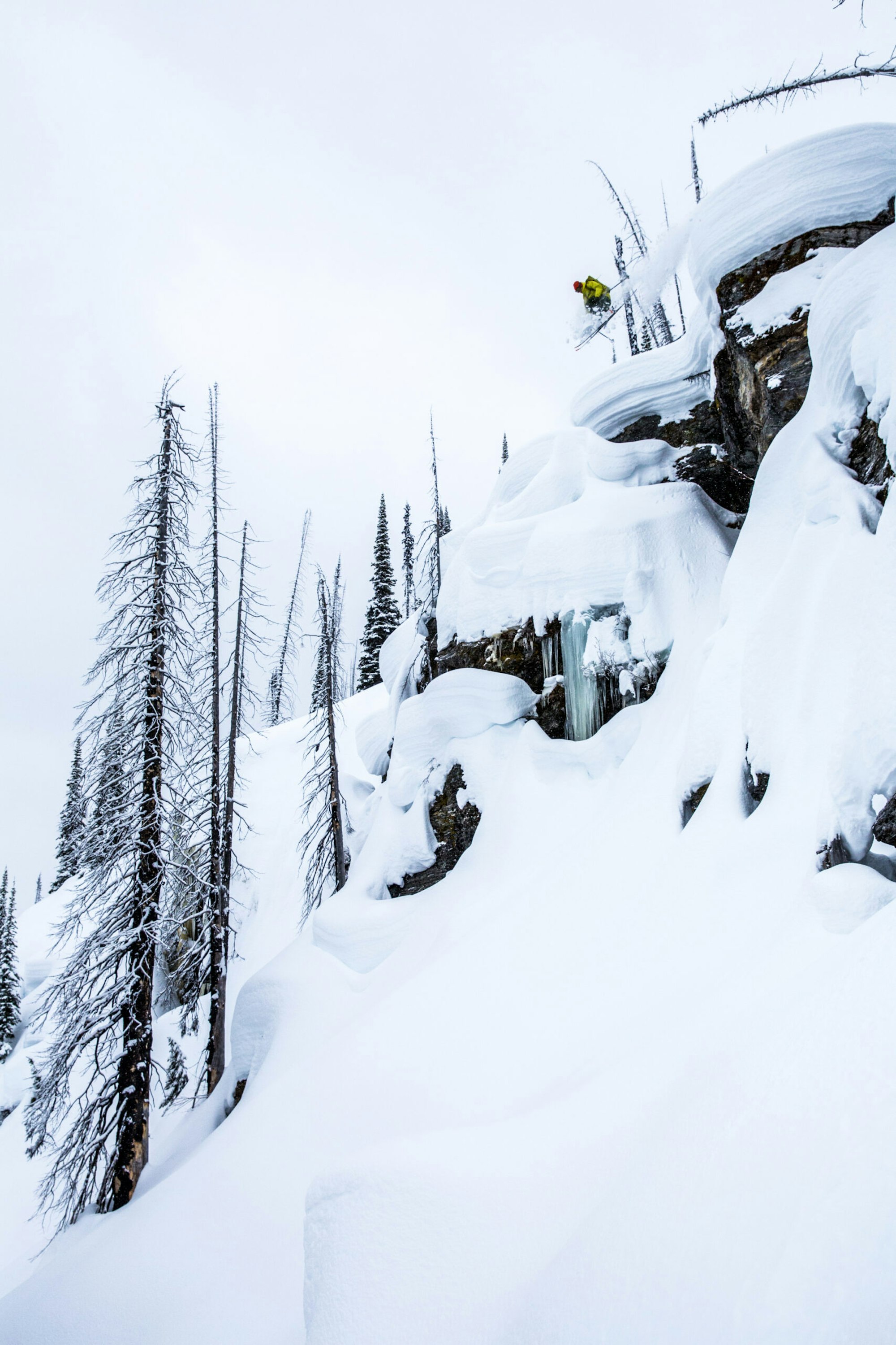 Skier Carter MacMillan jumping from a cliff into deep powder snow in Cherryville, BC