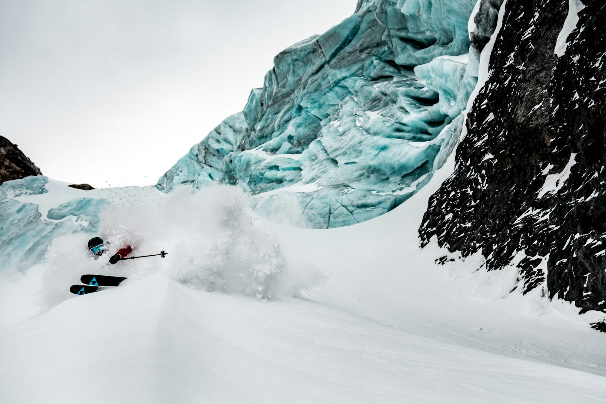 Skier William Larsson turning in deep powder snow on a mountain side in Engelberg, Che