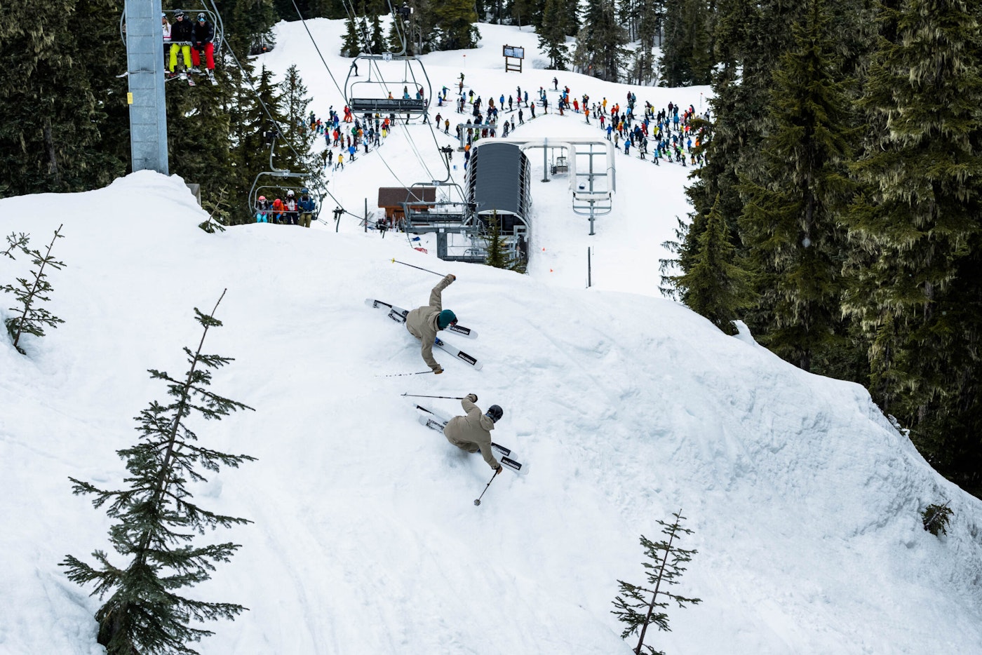 Skiers Wyatt Gentry and Carson Hilderbrandt skiing below a chairlift tower