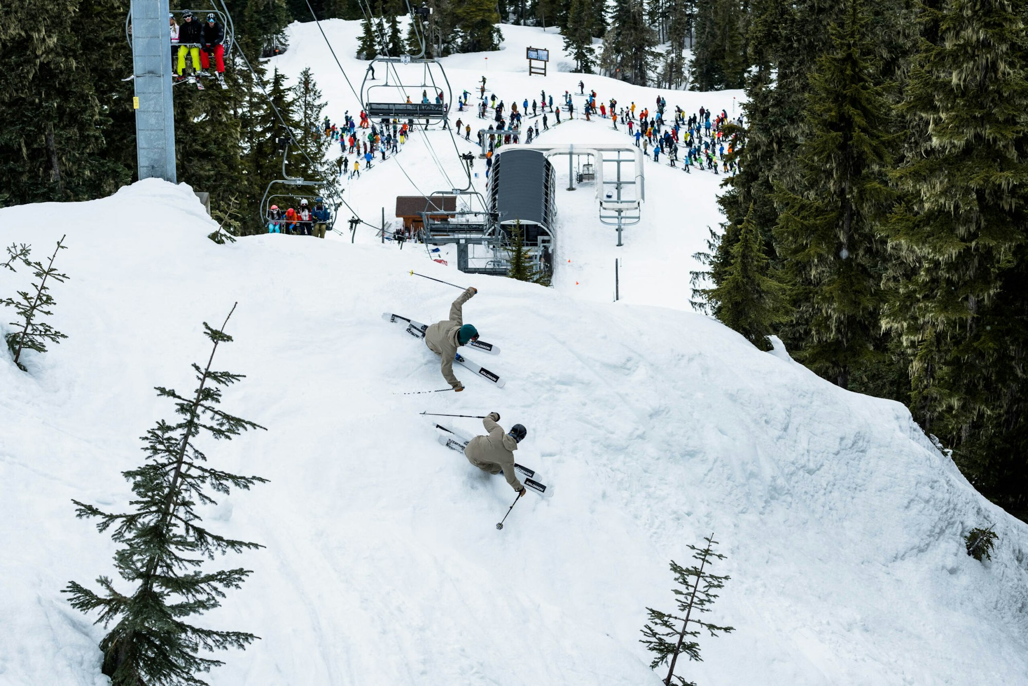 Skiers Wyatt Gentry and Carson Hilderbrandt skiing below a chairlift tower