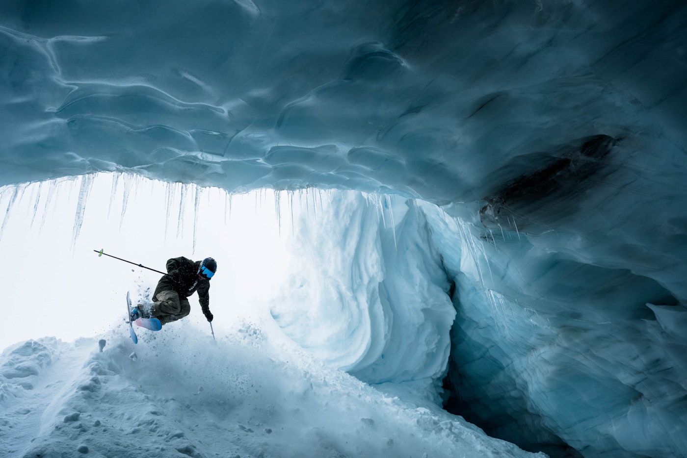 Skier Chris Rubens skiing mid air into an icy tunnel