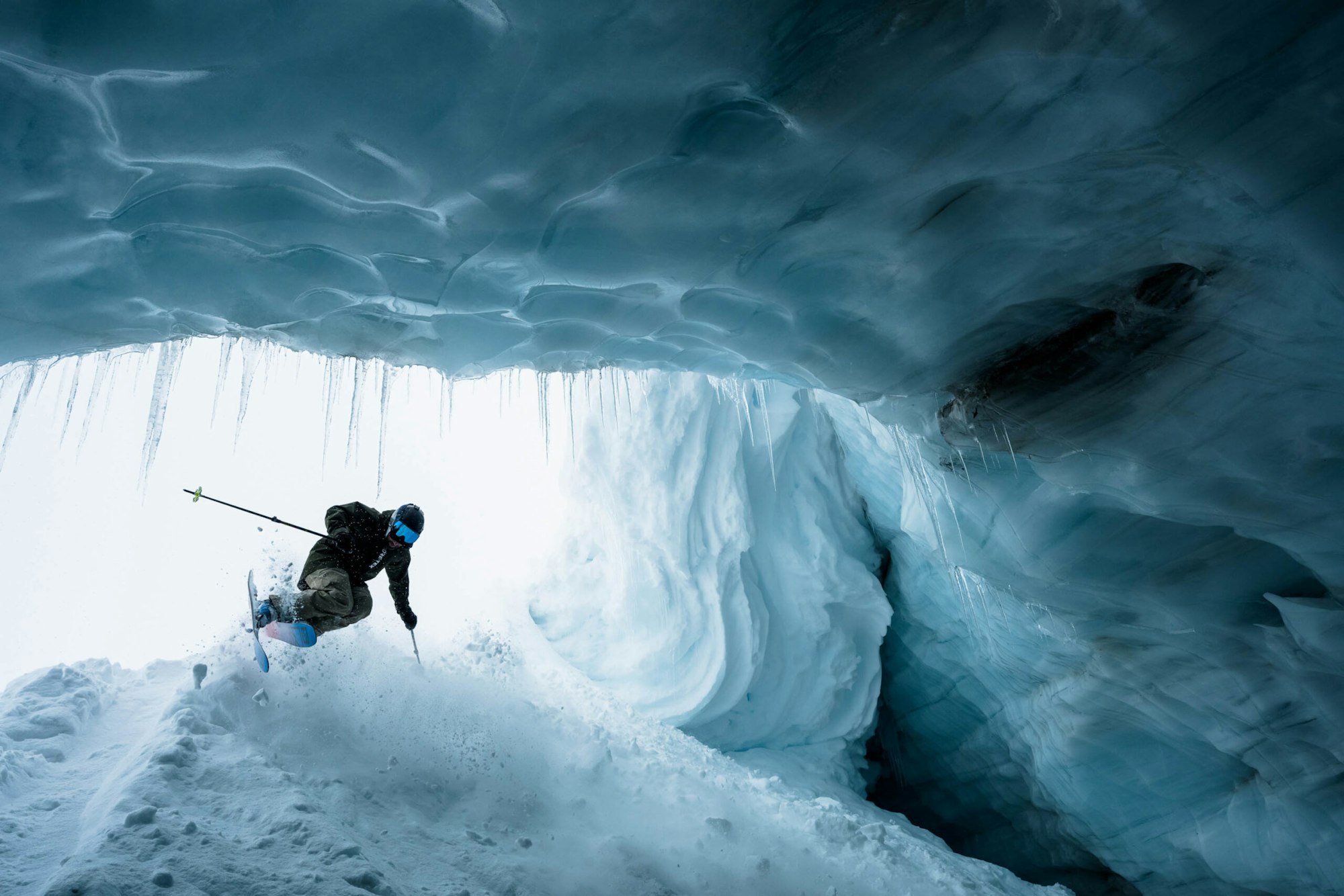 Skier Chris Rubens skiing mid air into an icy tunnel