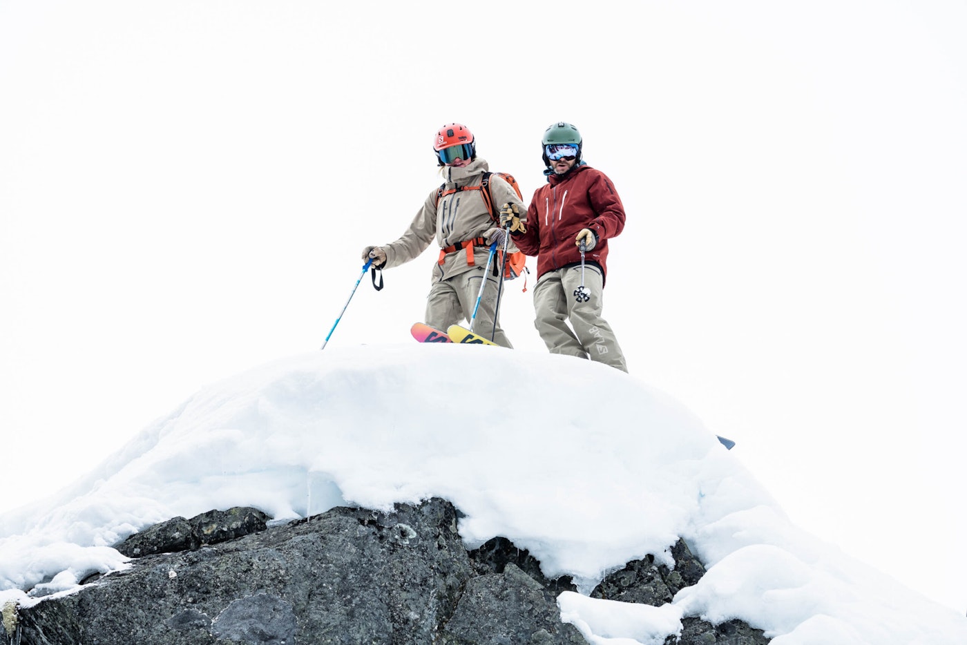 Skiers Luke Gentry and Mike Douglas looking over the edge of a snowy cliff