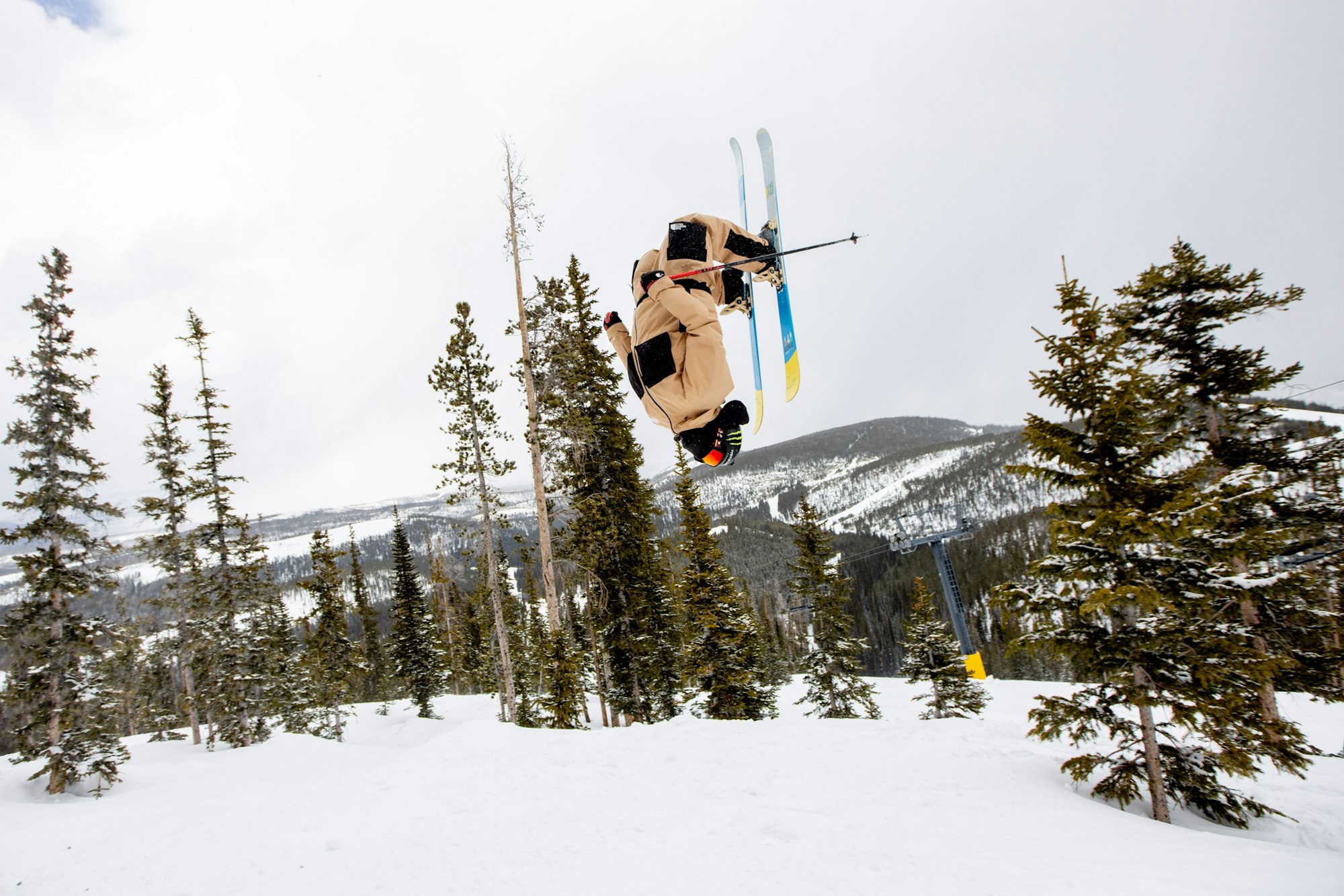 Skier Ben Smith backflipping in a snowy forest