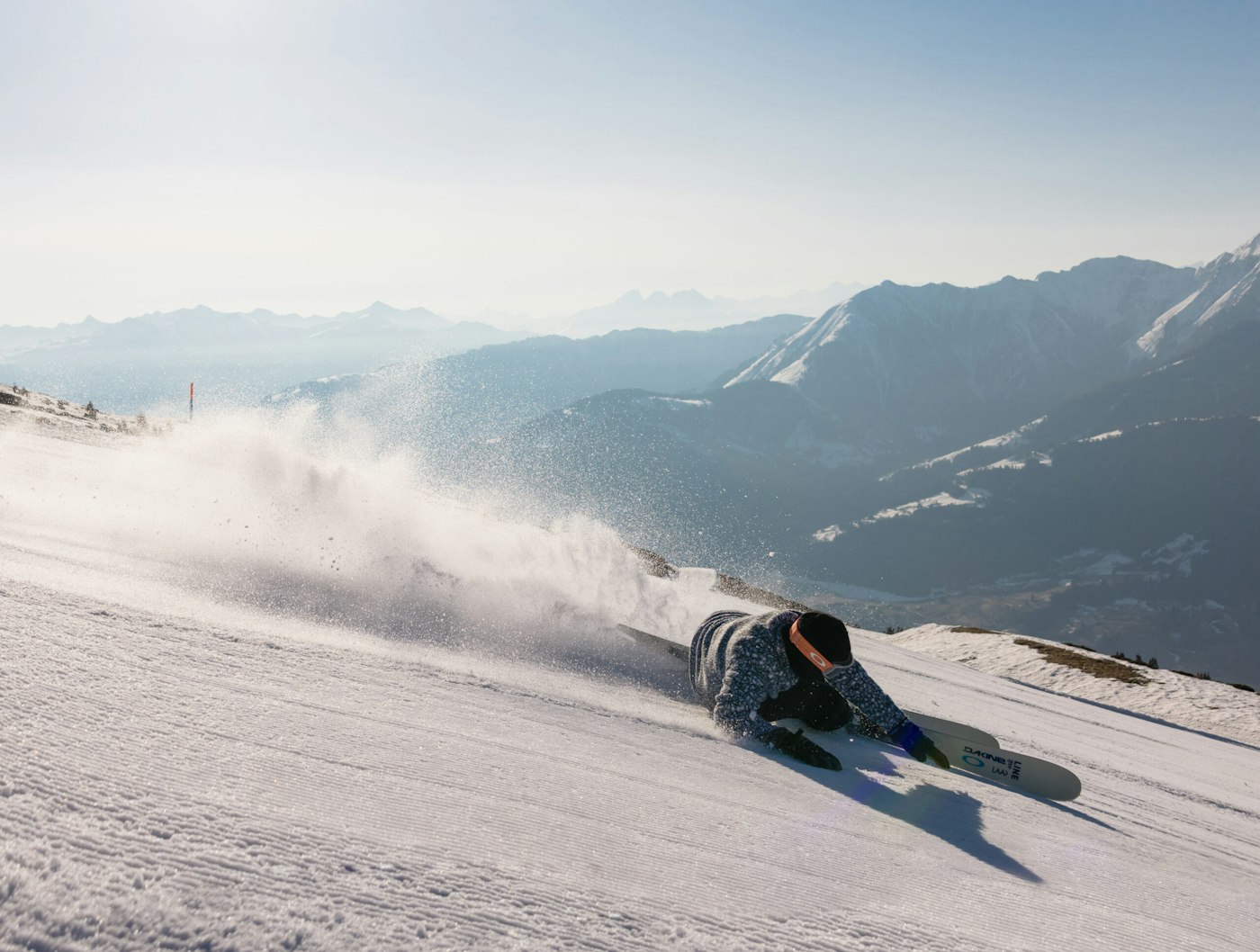 Skier carving a turn down a groomed trail