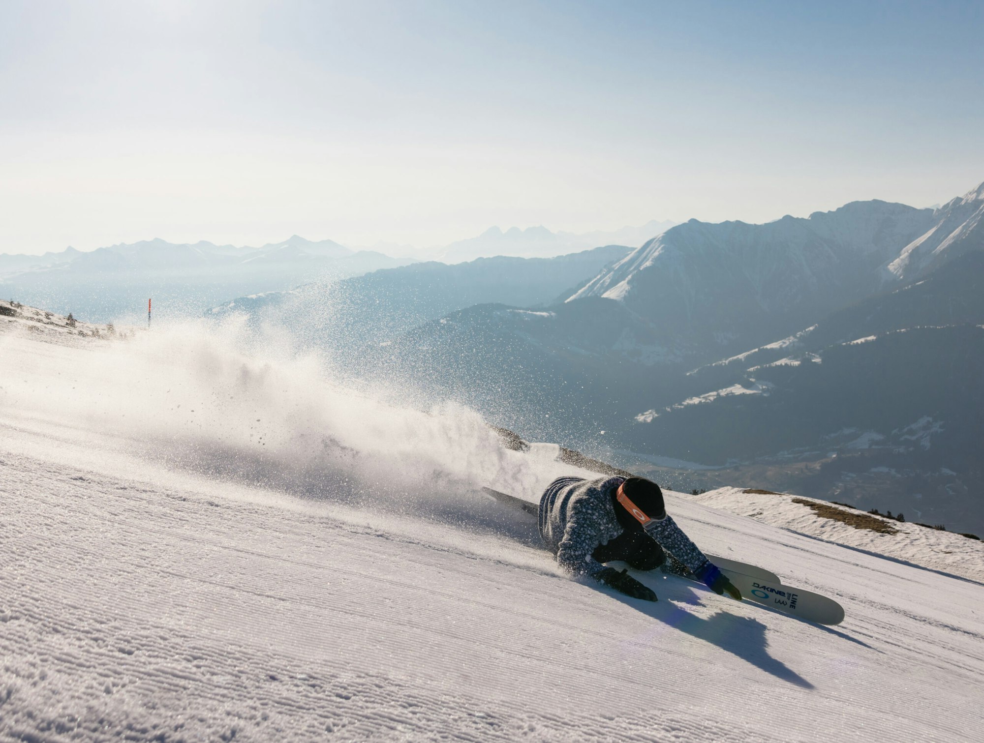 Skier carving a turn down a groomed trail