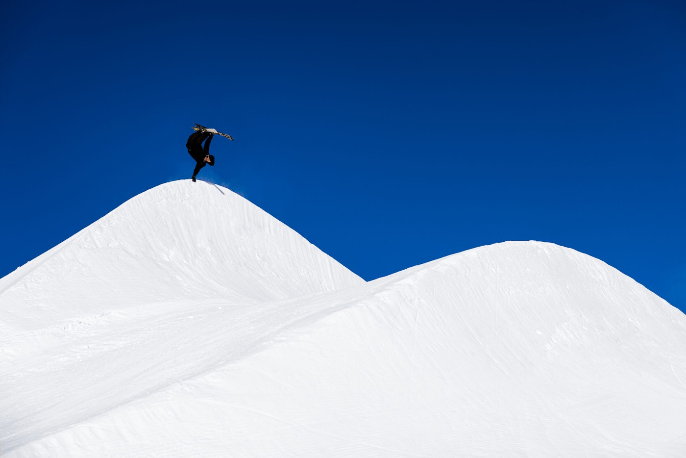 Skier mid air off a lip grabbing side of their skis
