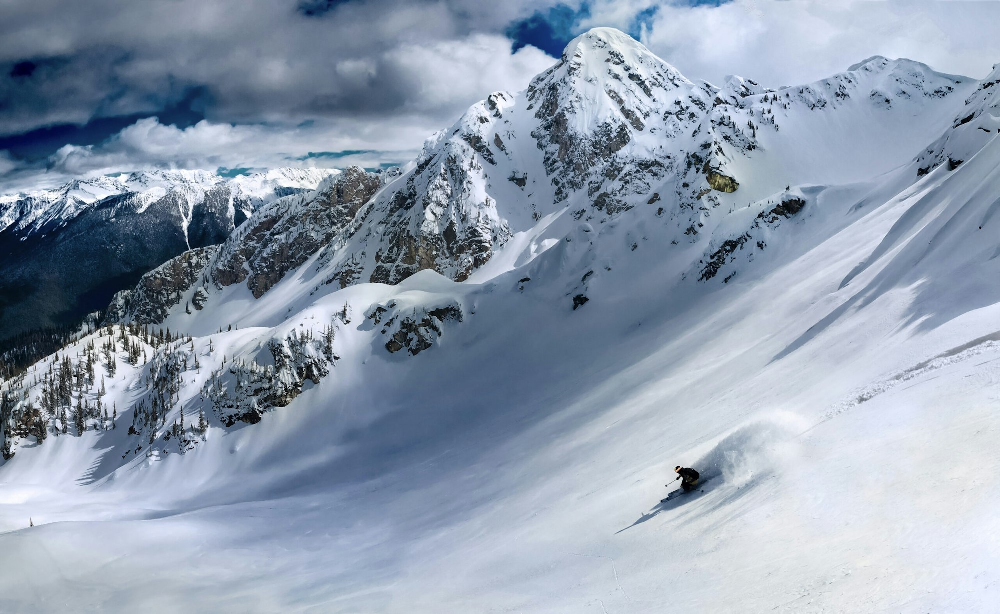 Skier turning in deep snow in a snowy mountain basin
