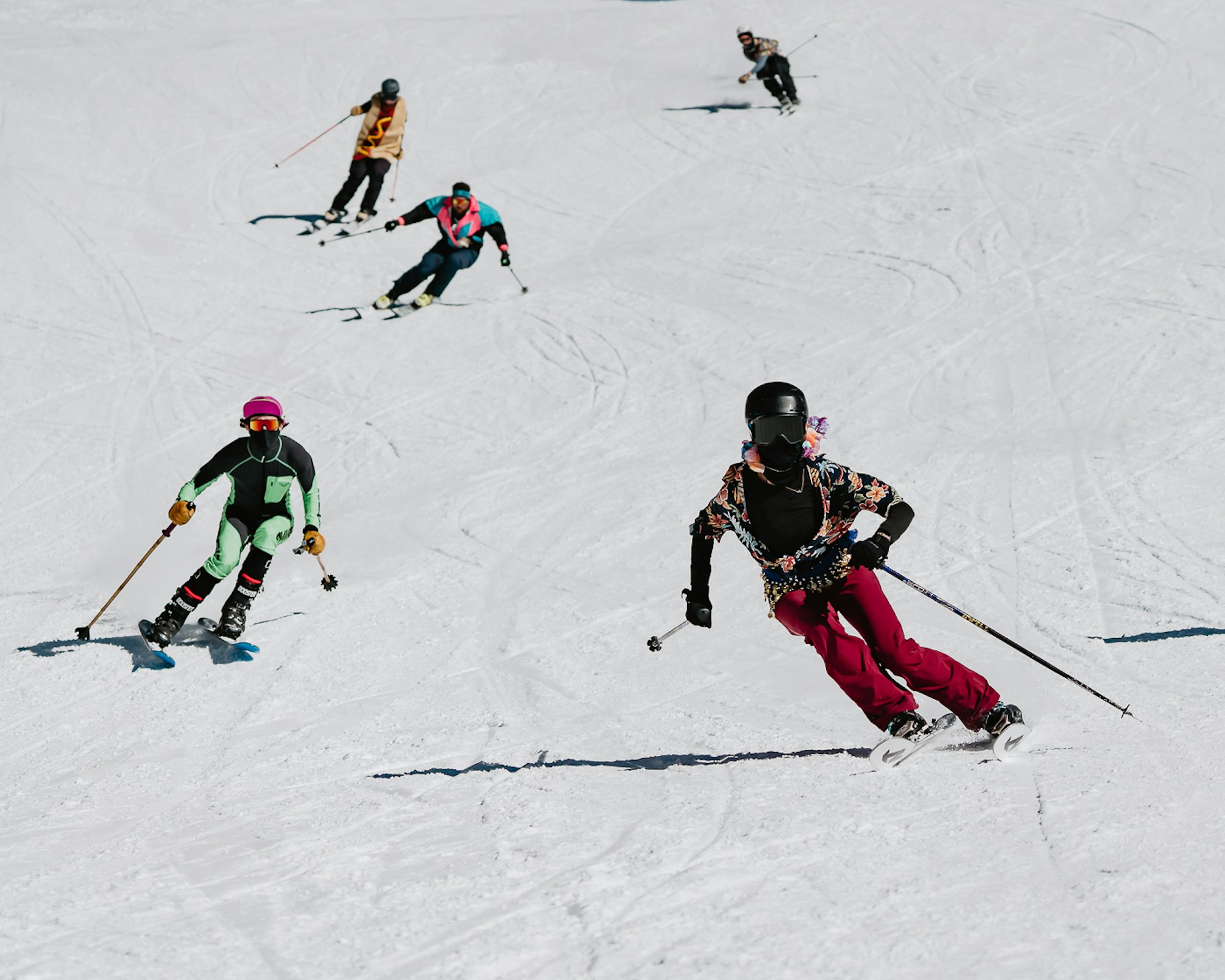Skiers in costumes ski down a snowy slope