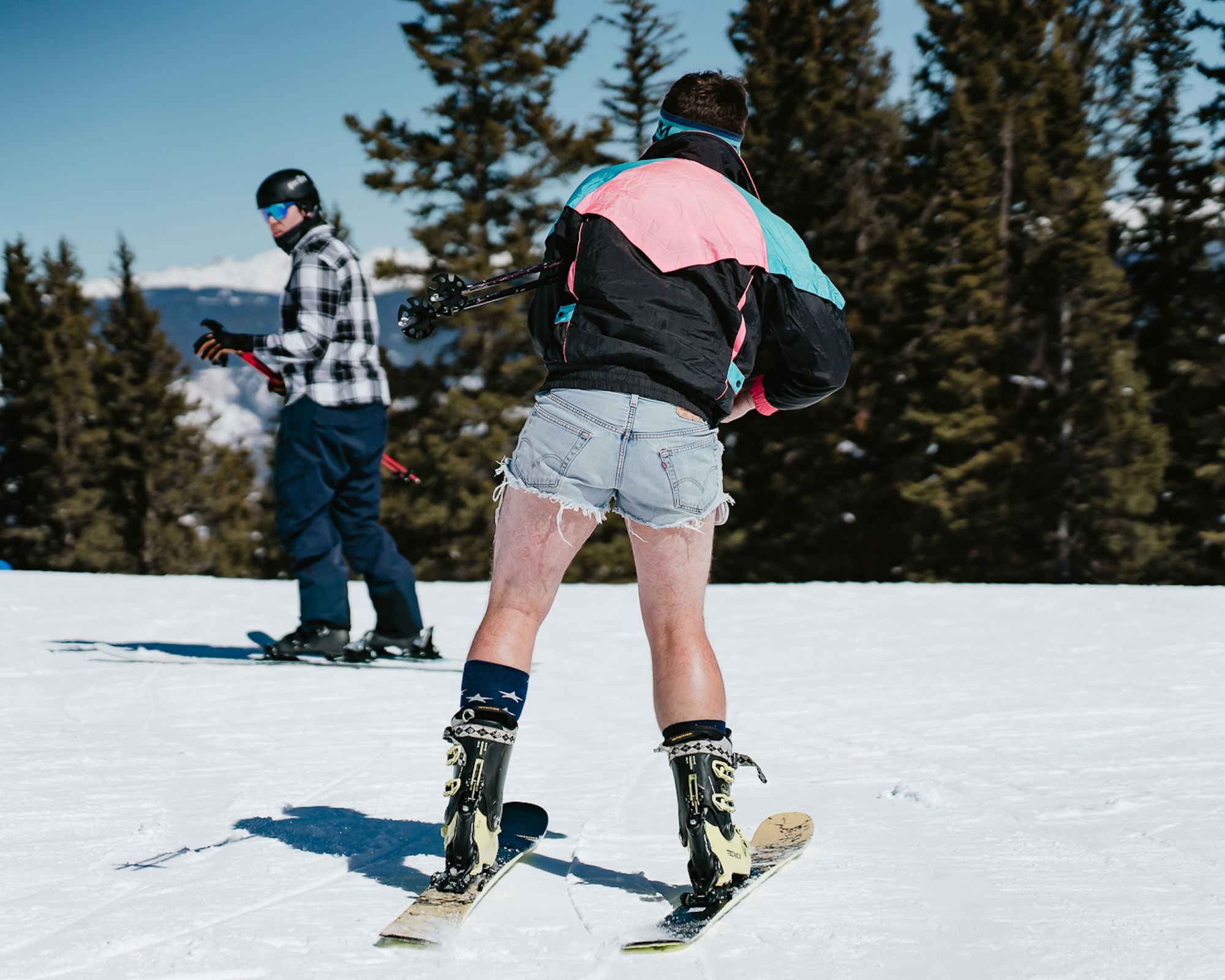 Skier in jean cutoff shorts skating across the snow