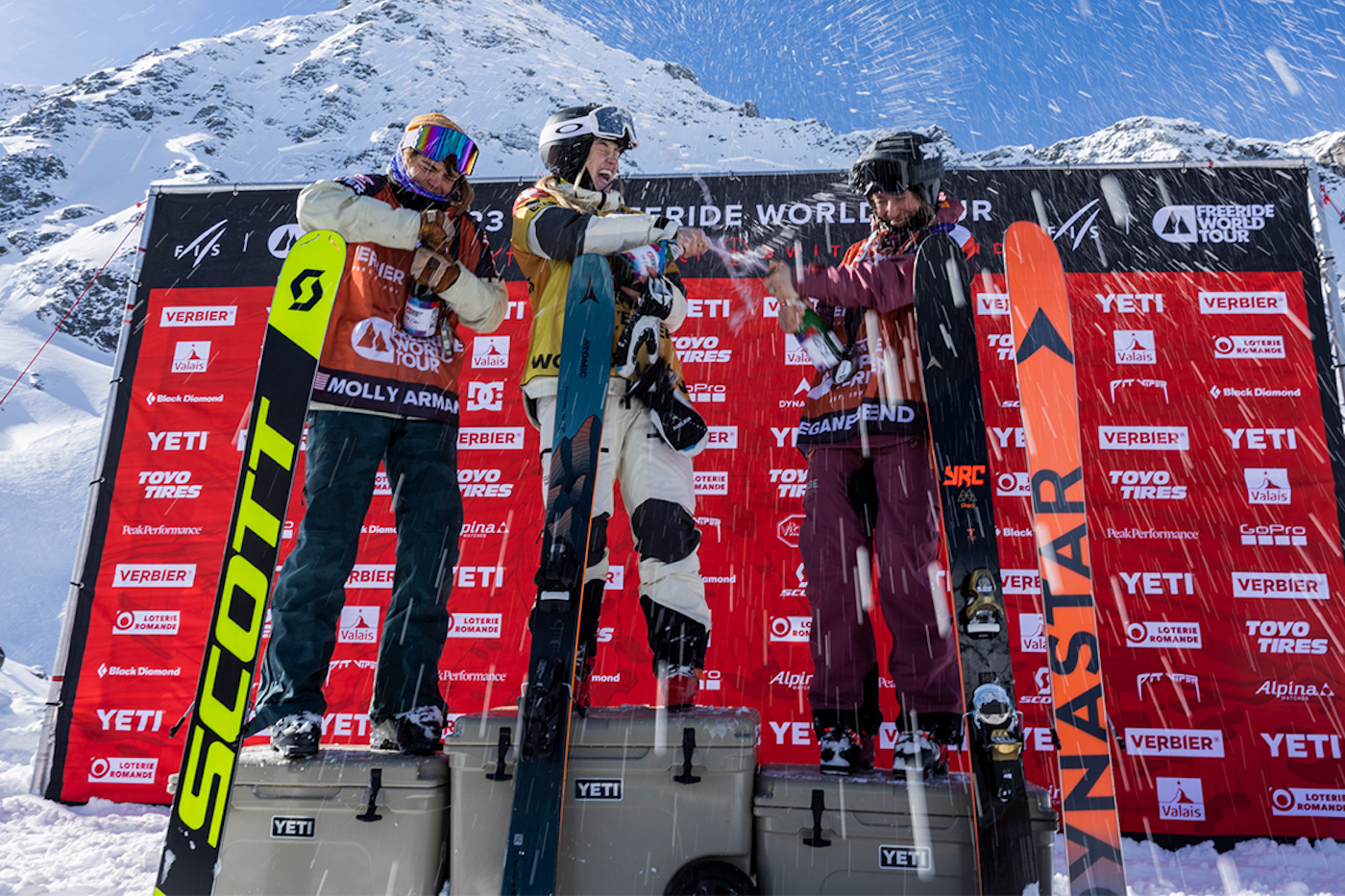 Freeride world tour skiers on the podium spraying each other with champagne