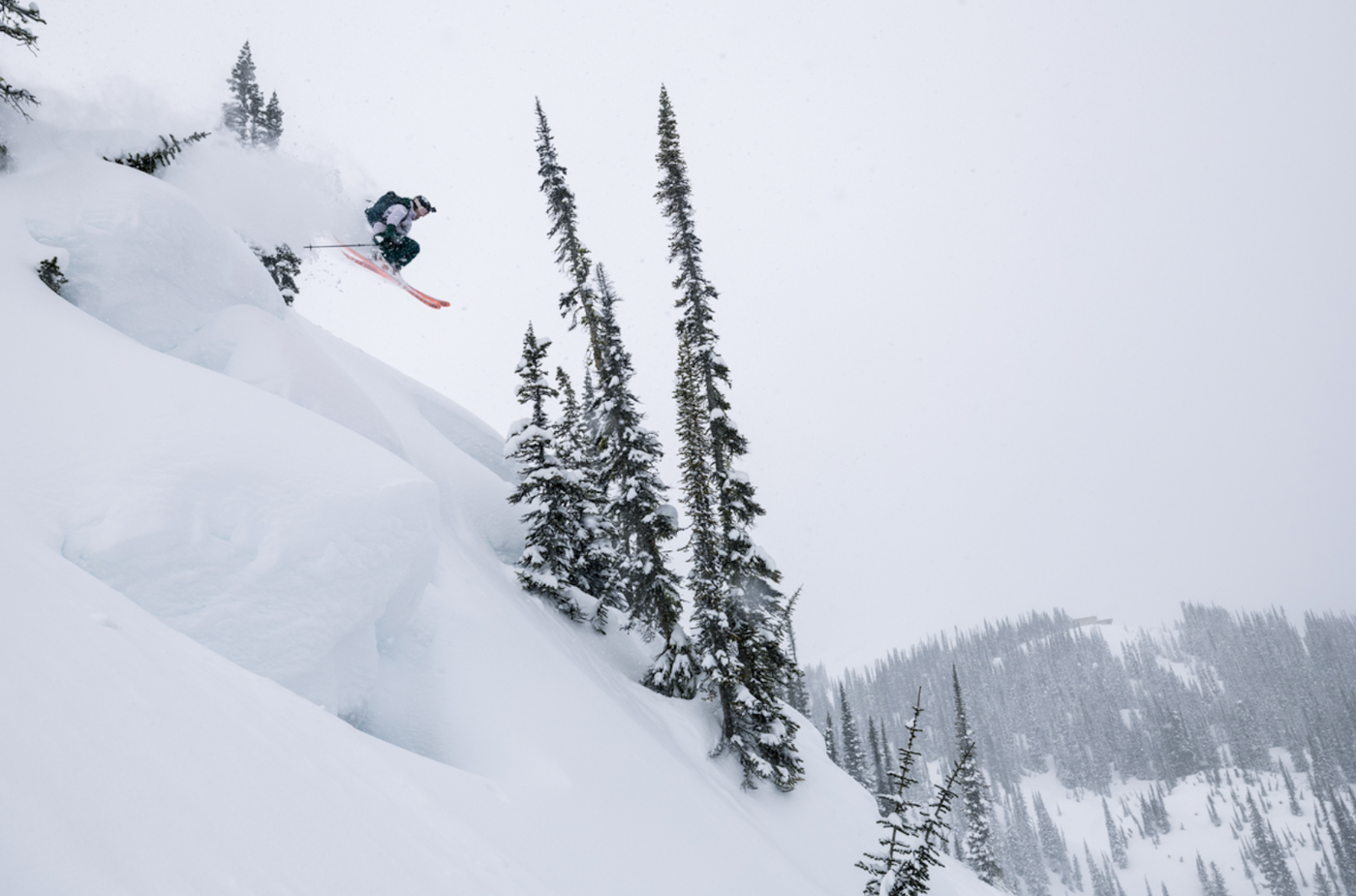 Cate Zeliff jumping off a cliff on skis into deep snow