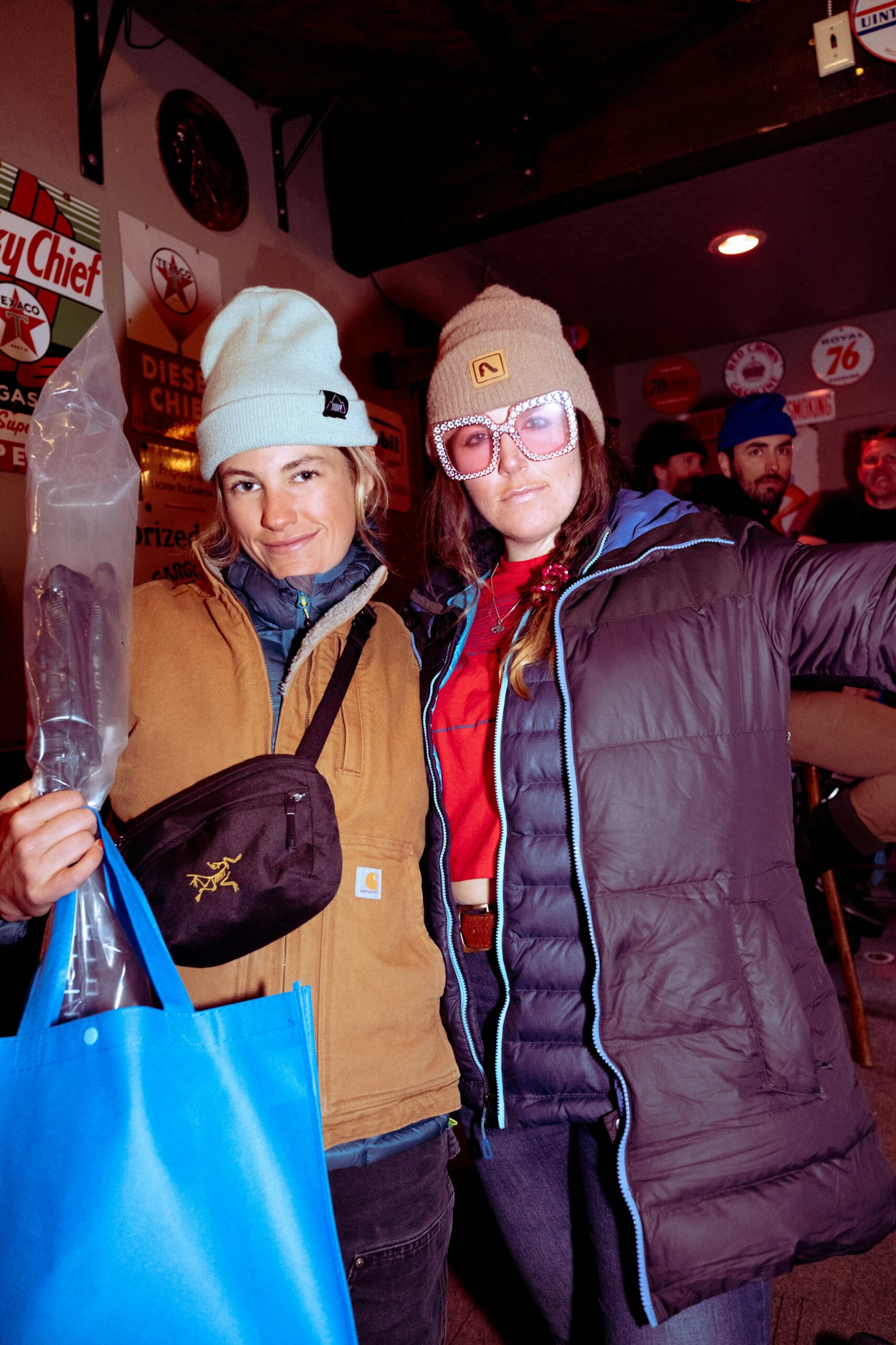 Two women posing for a photo at a bar