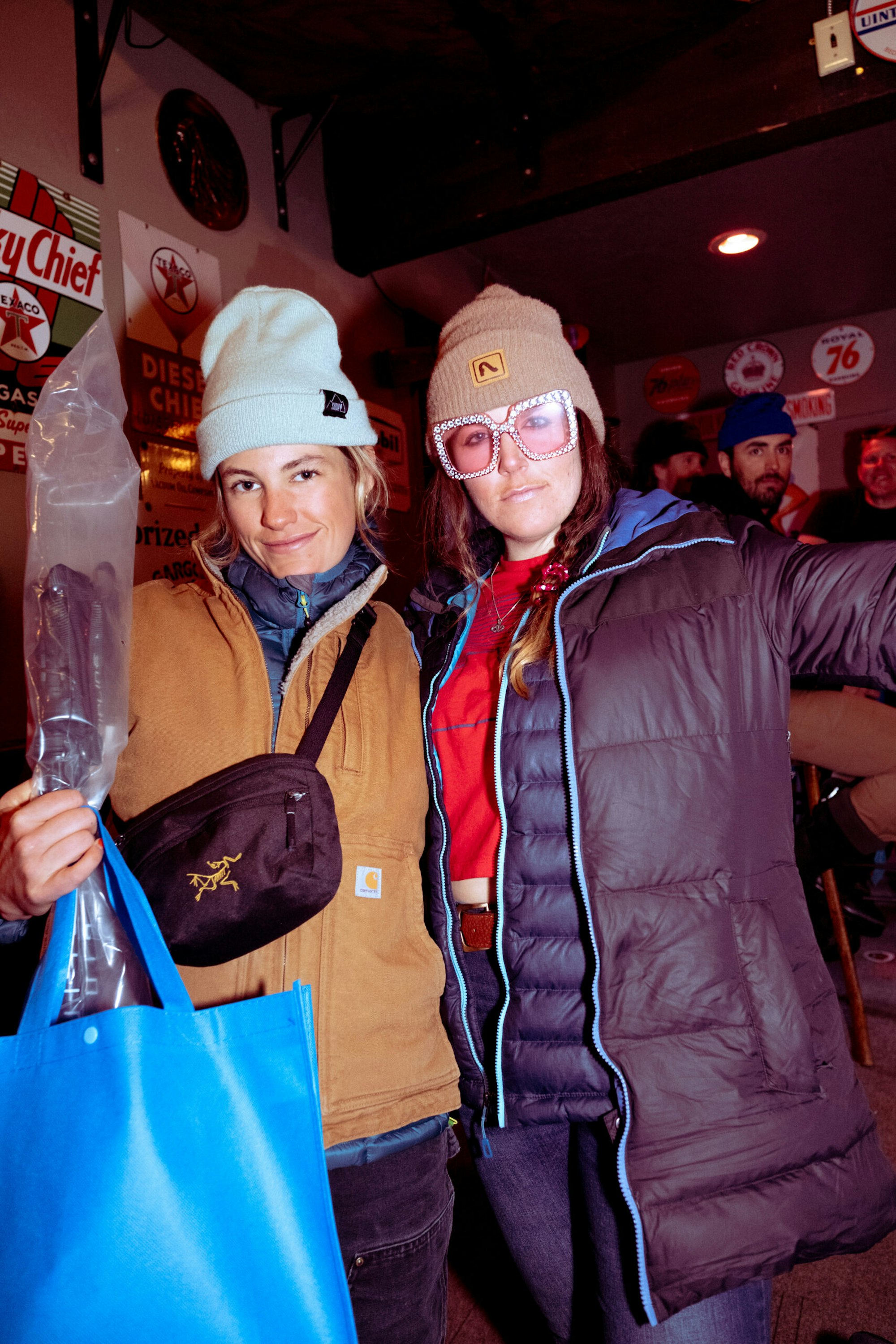 Two women posing for a photo at a bar