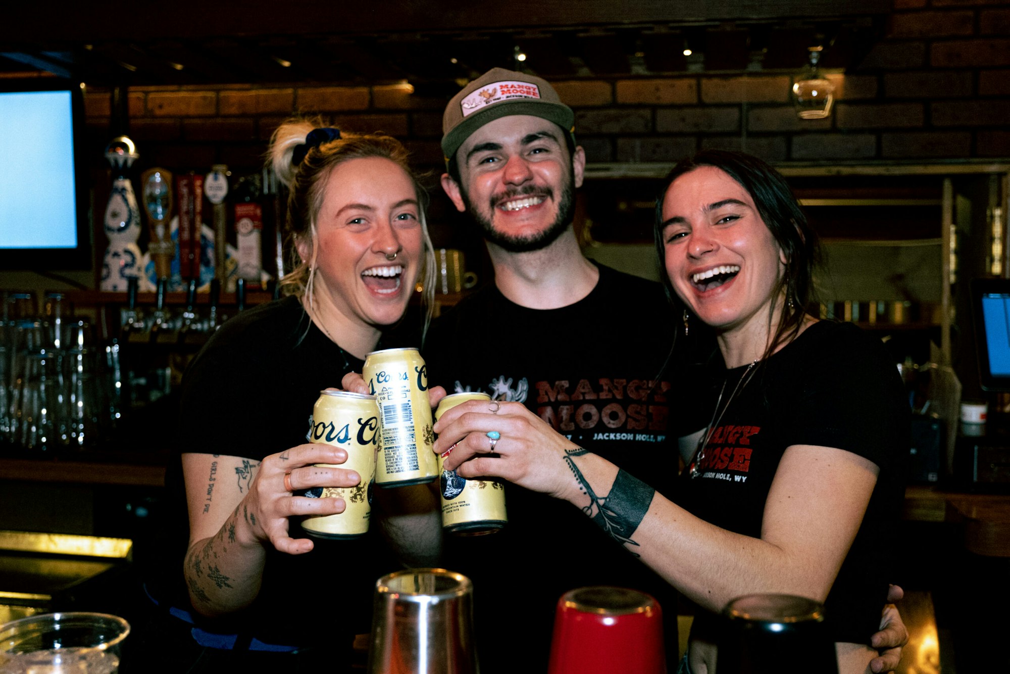 Three people cheersing with Coors Banquet