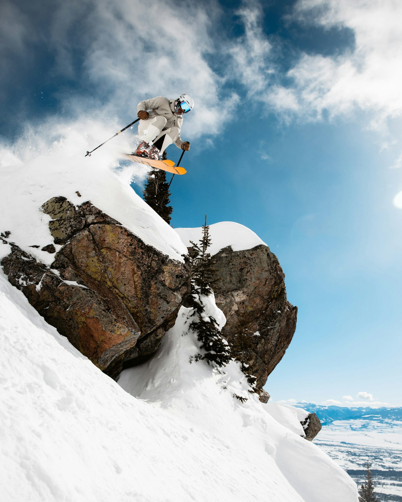 Skier jumps from rocky cliff on skis