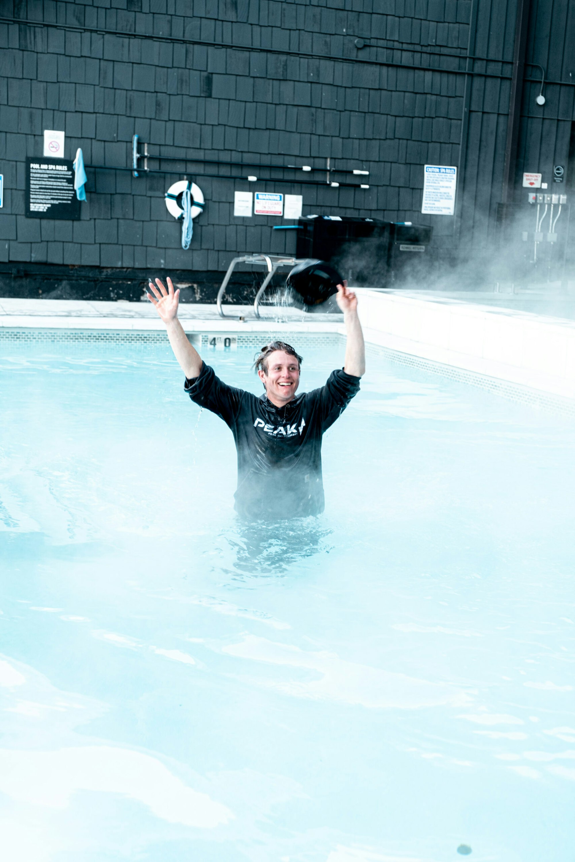 Man stands in a heated pool in his clothes