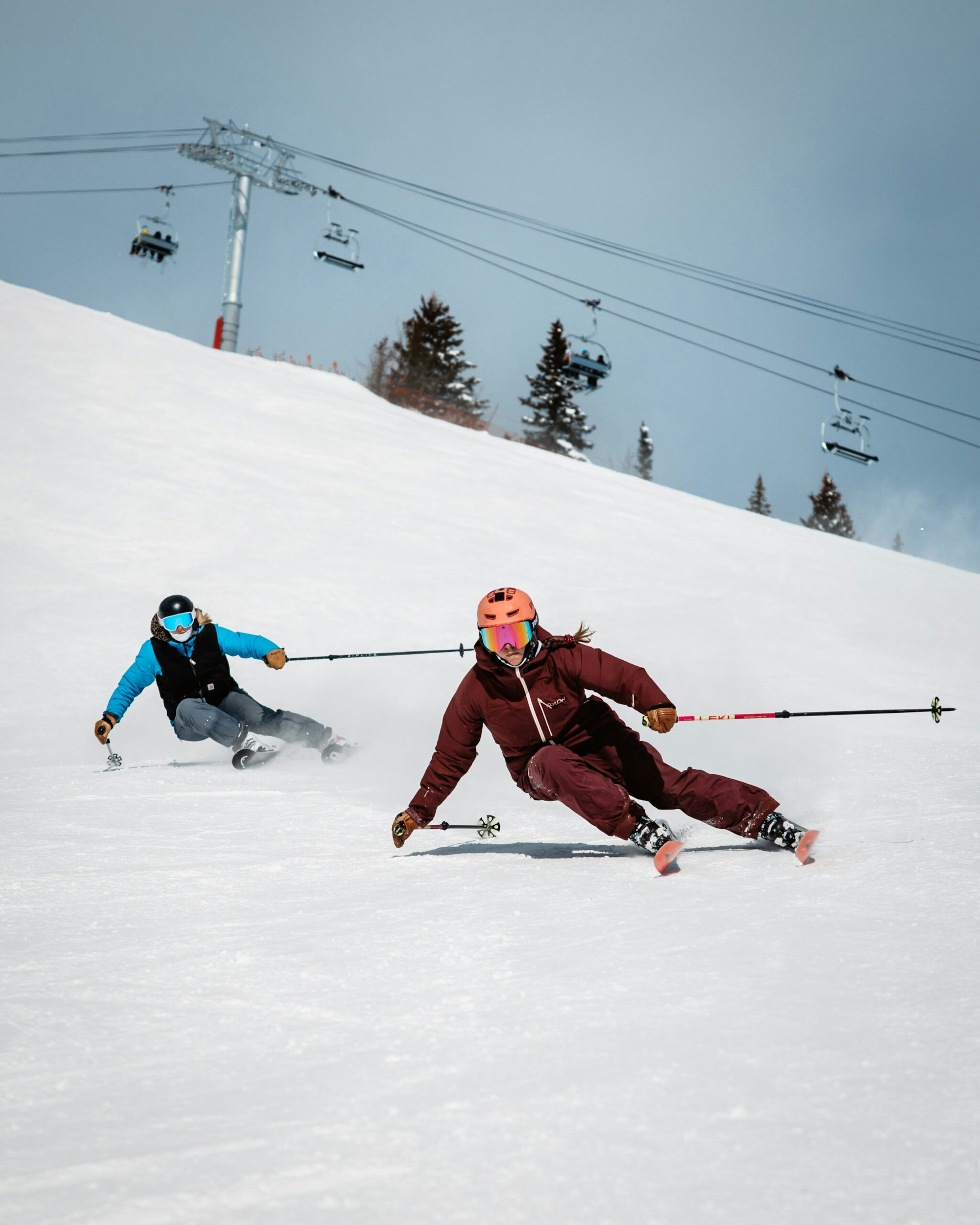 two skiers turning in tandem down a snowy hill