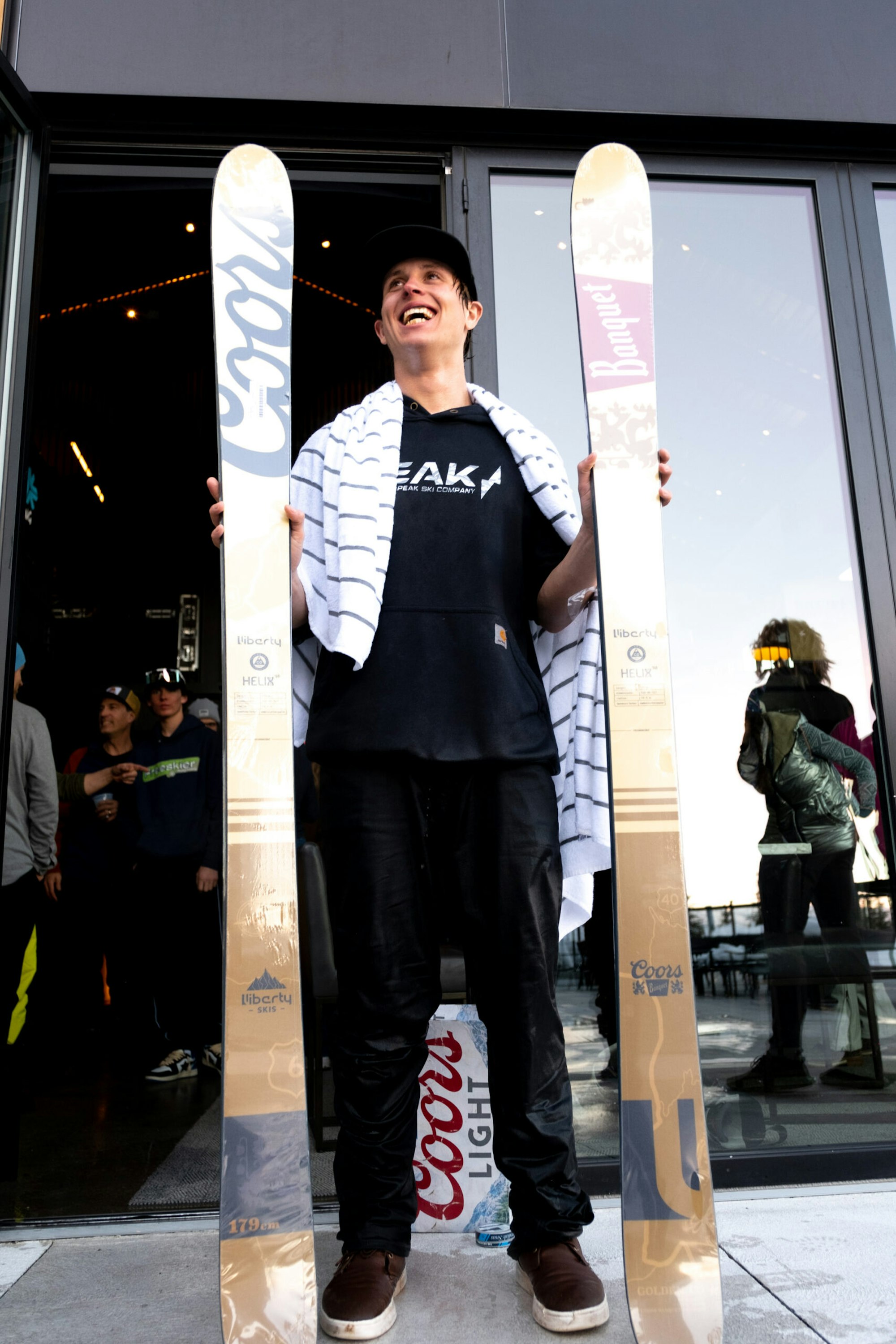 Man holding coors branded skis