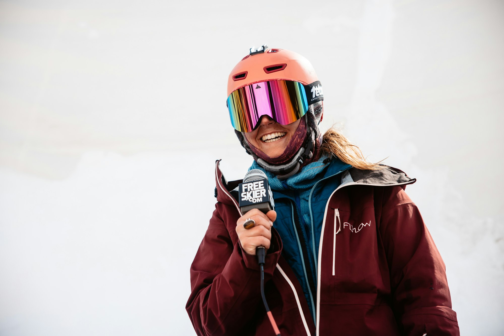 A skier holds a microphone to their mouth