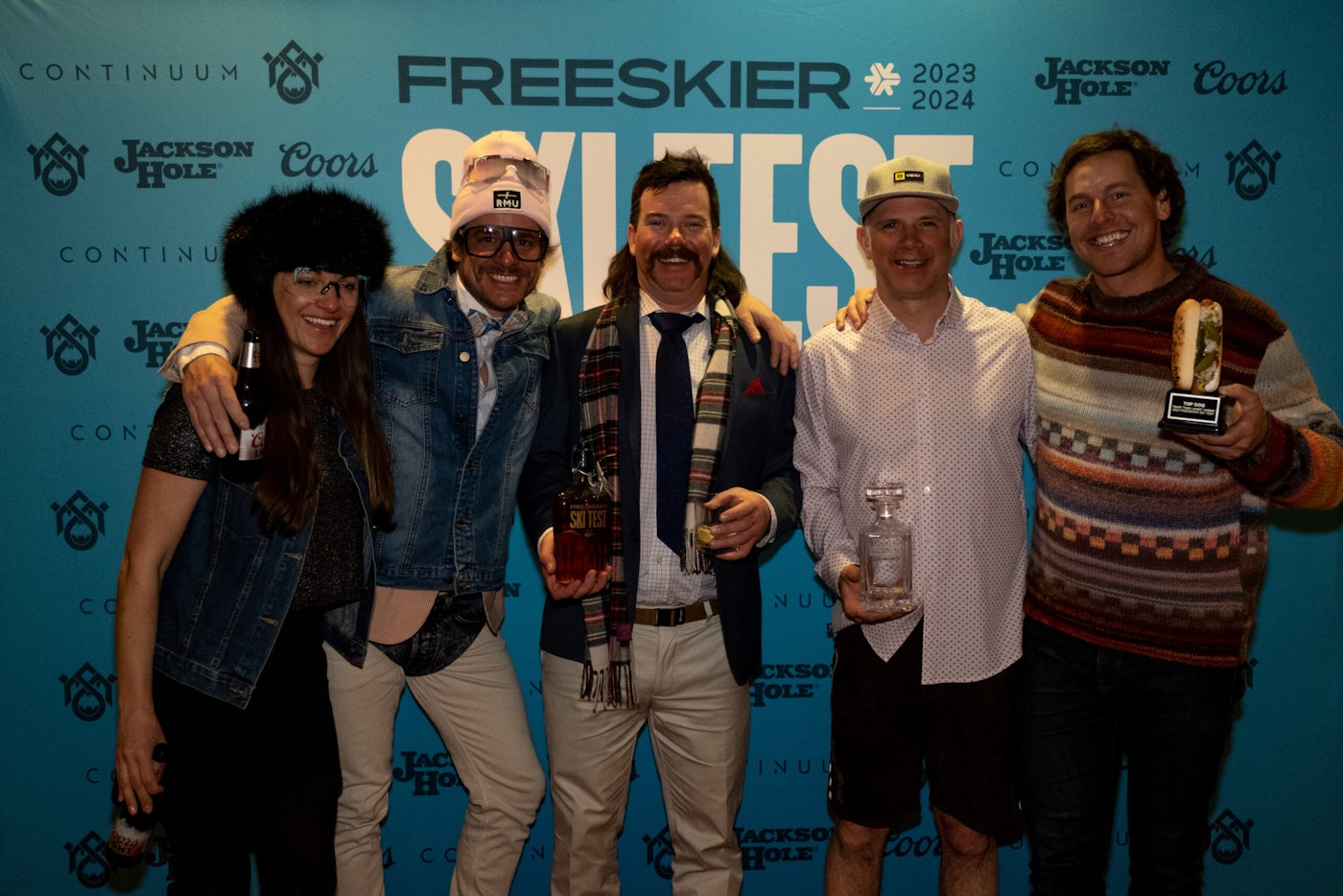 Five people pose in front of a FREESKIER banner for a picture