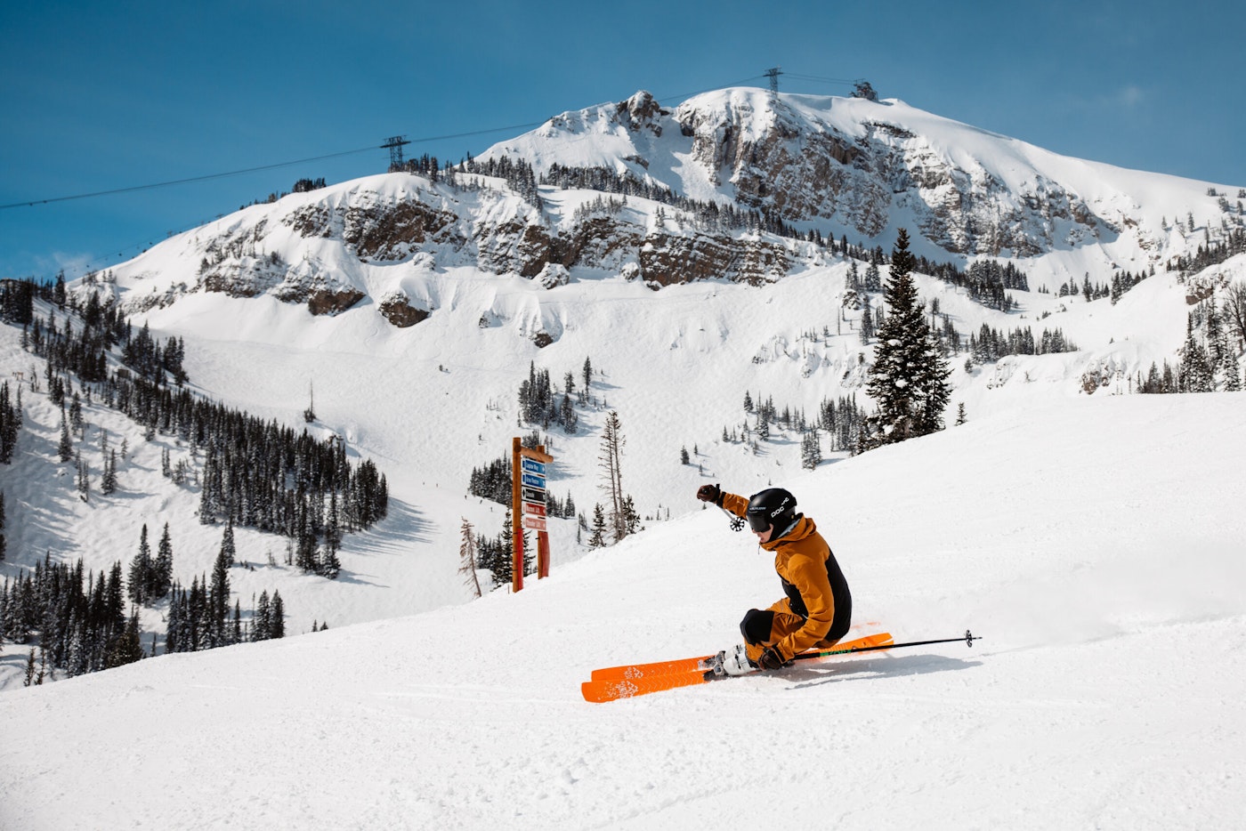 A skier makes a sharp turn through groomed snow