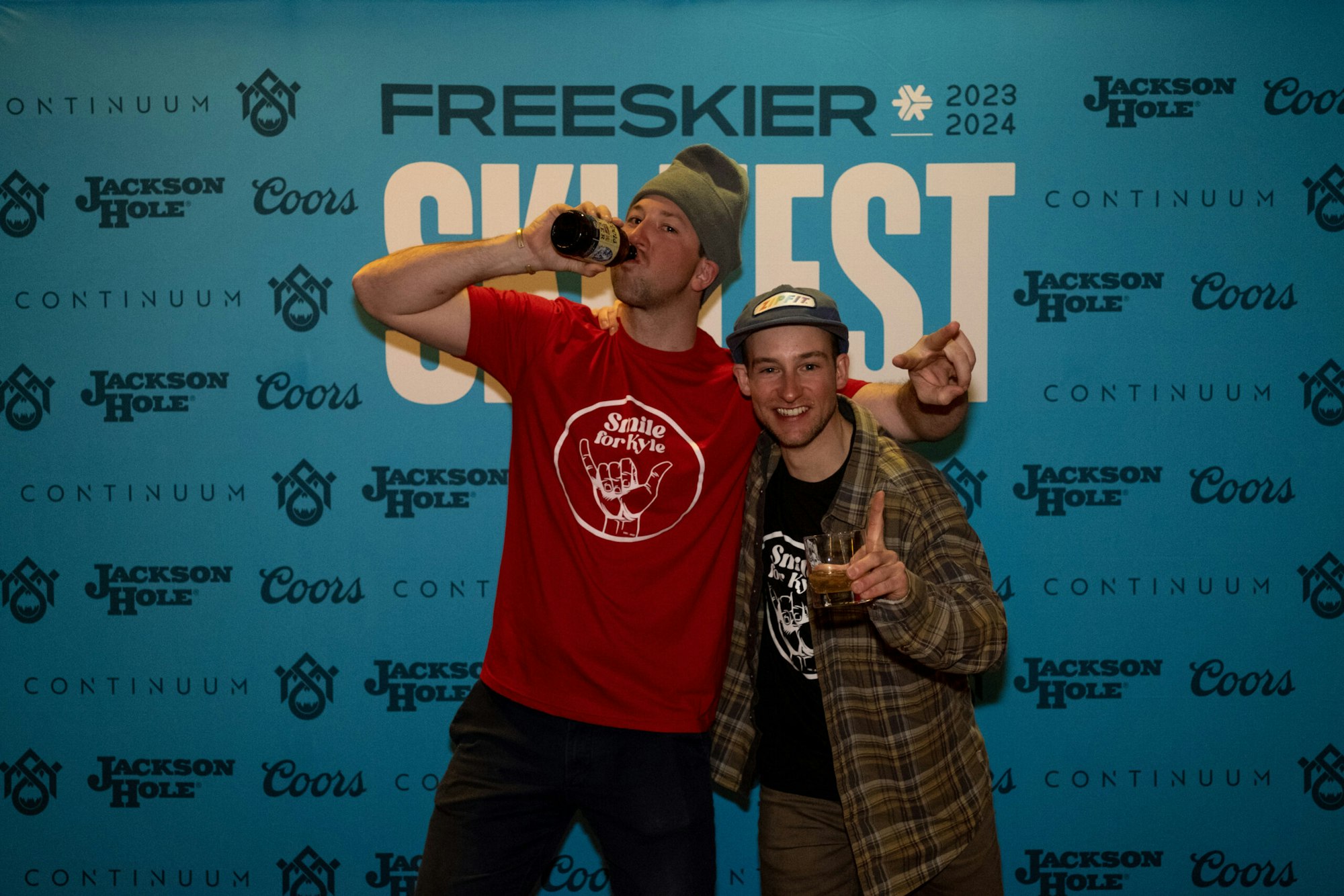 2 people pose in front of FREESKIER banner