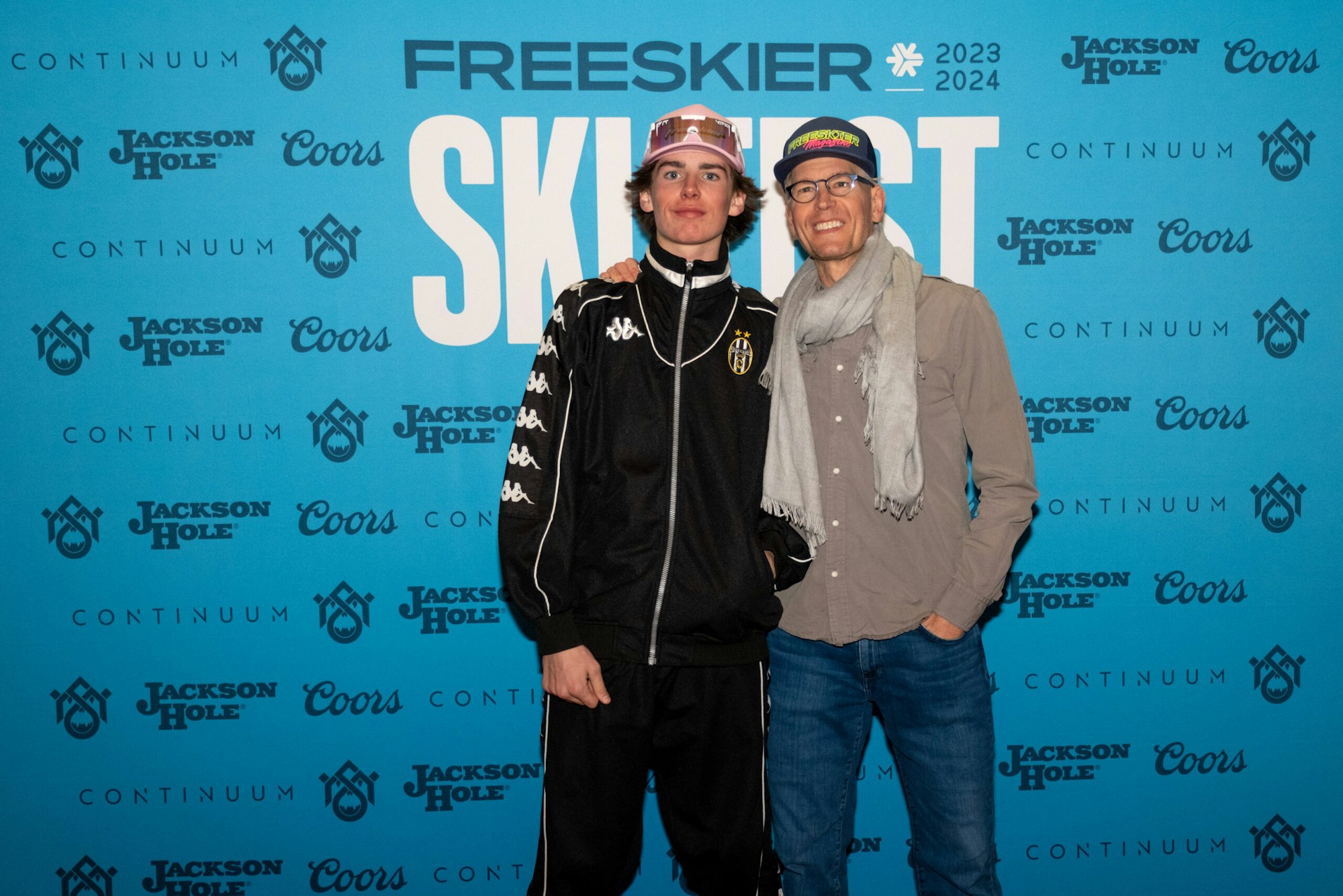 2 people pose in front of FREESKIER banner