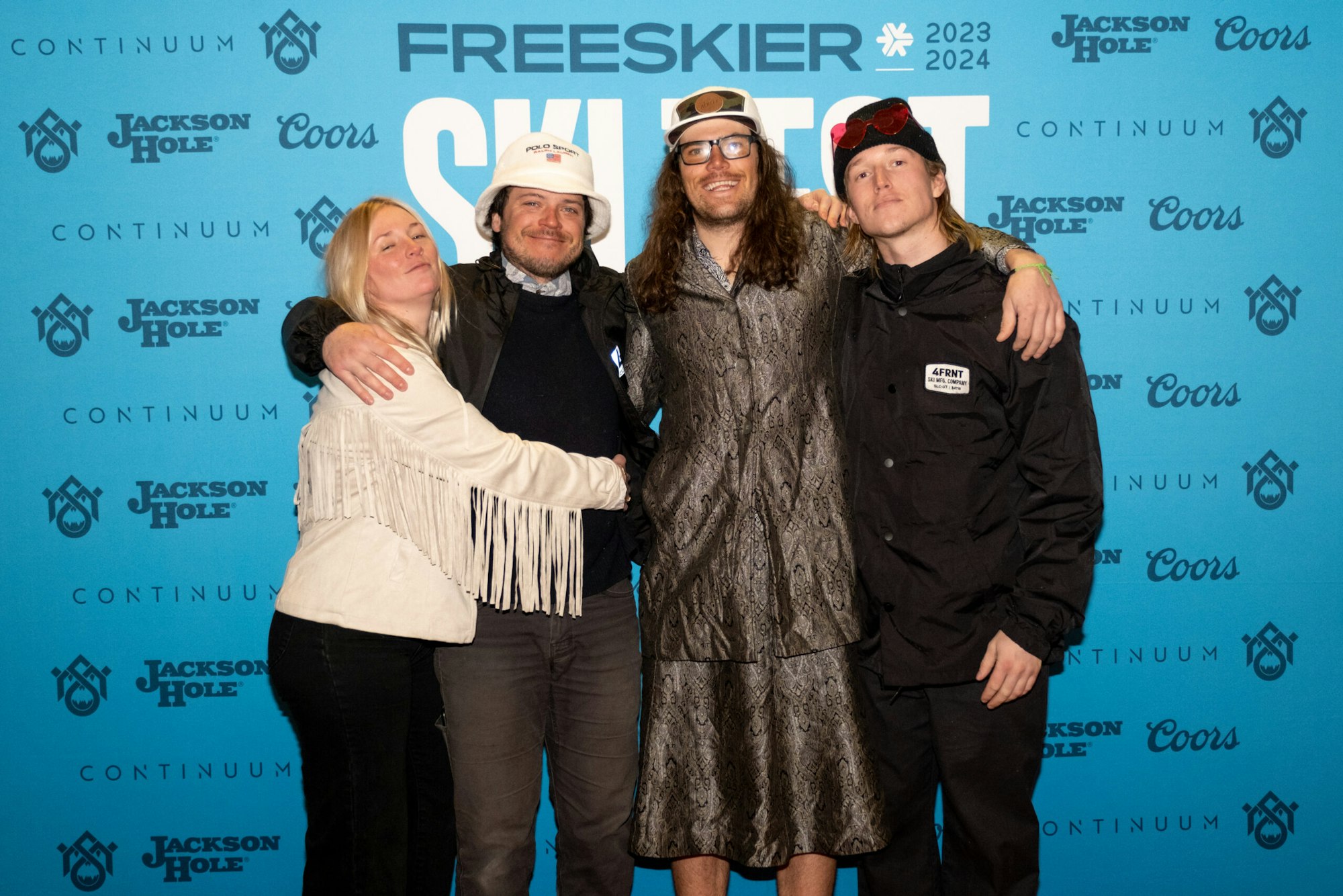 four people pose in front of FREESKIER banner