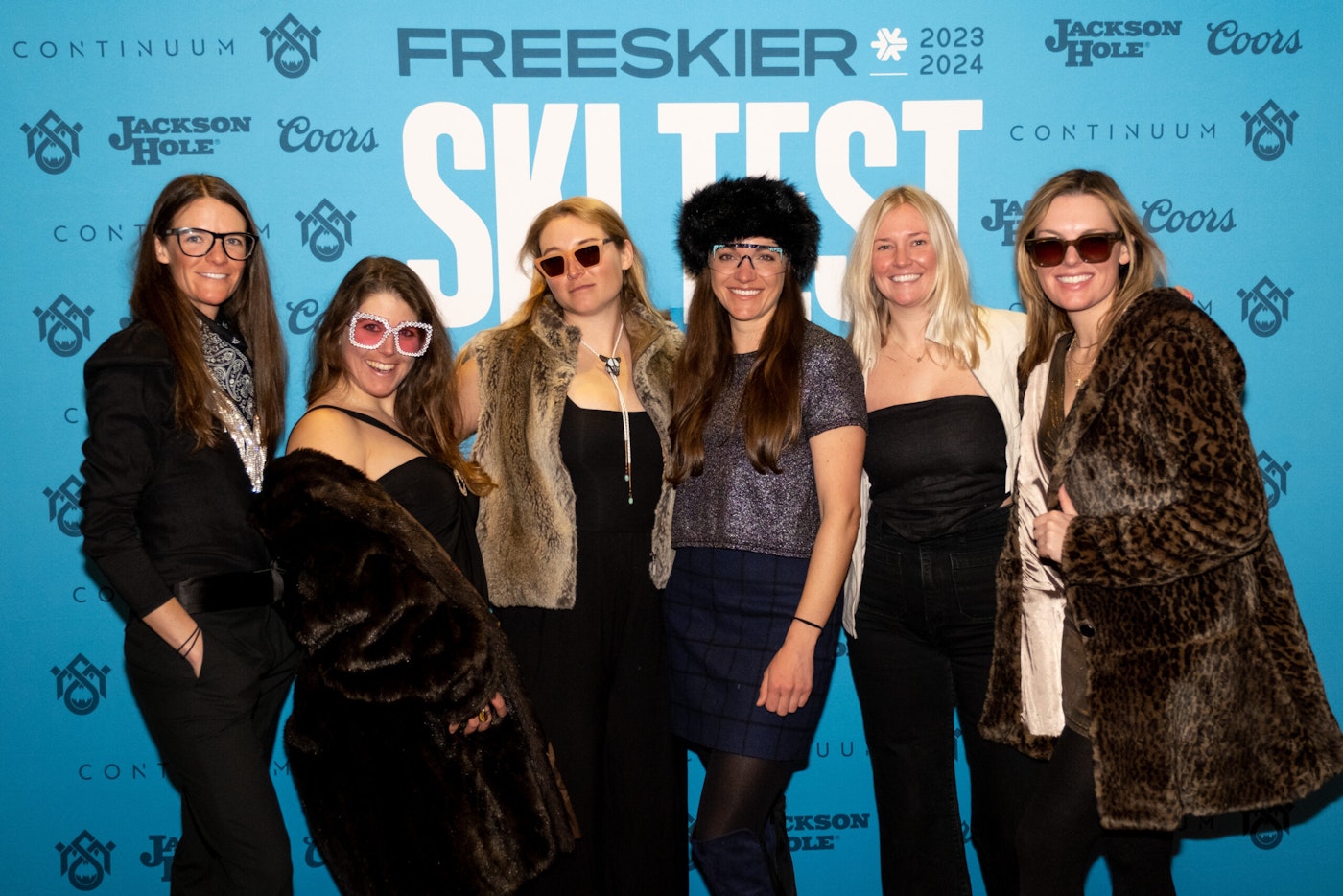 Six people pose in front of FREESKIER banner