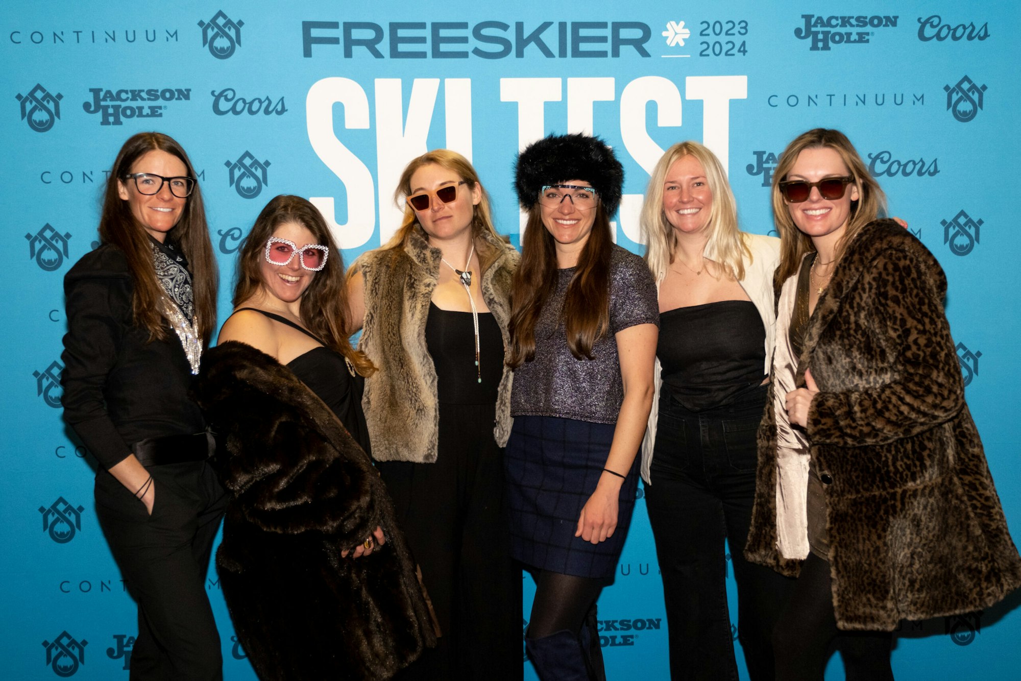 Six people pose in front of FREESKIER banner