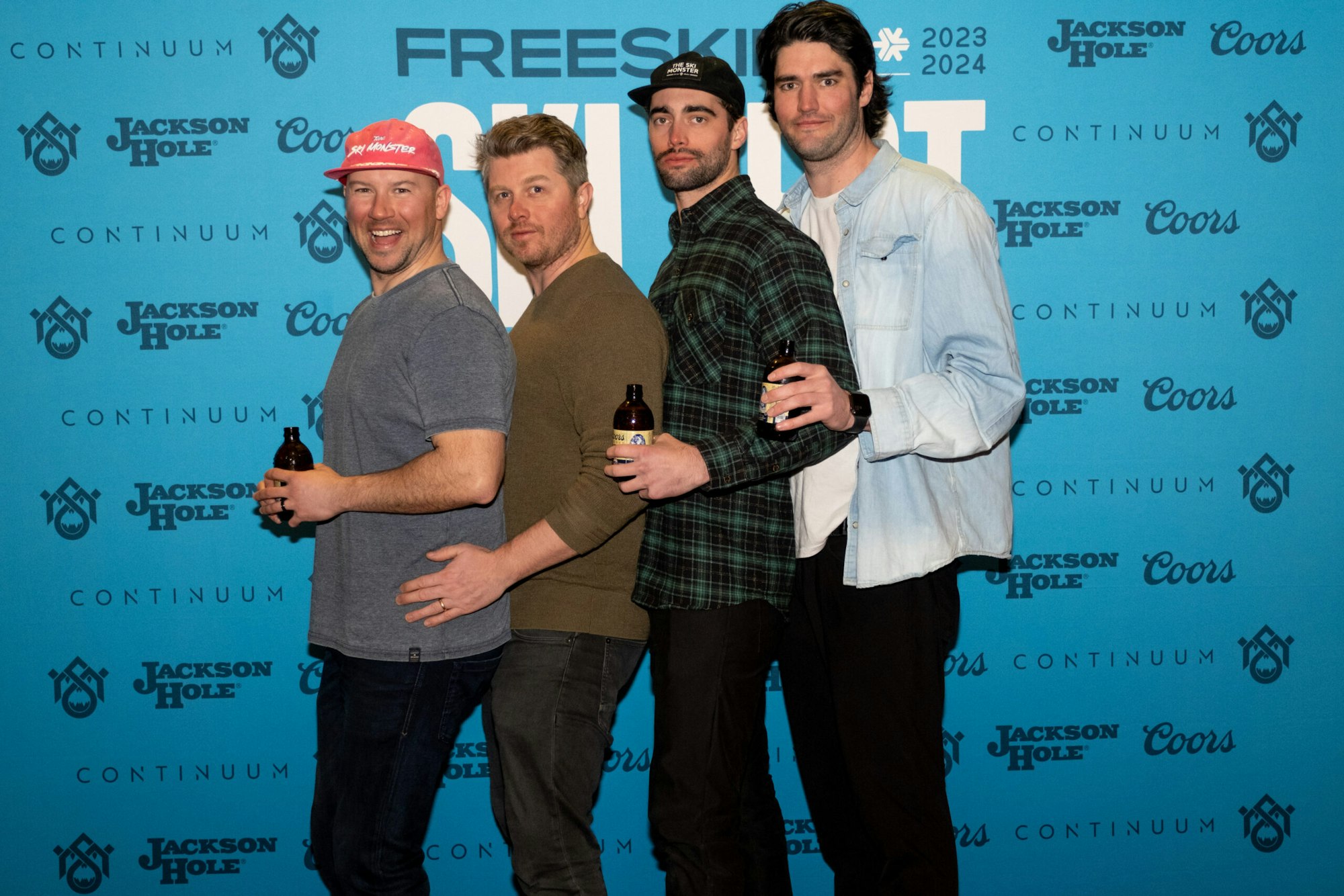 four people pose in front of FREESKIER banner
